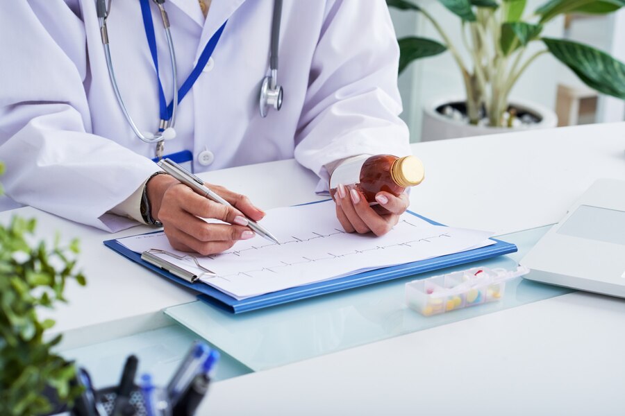 A doctor prescribing medicines to the patient keeping in view the reports.