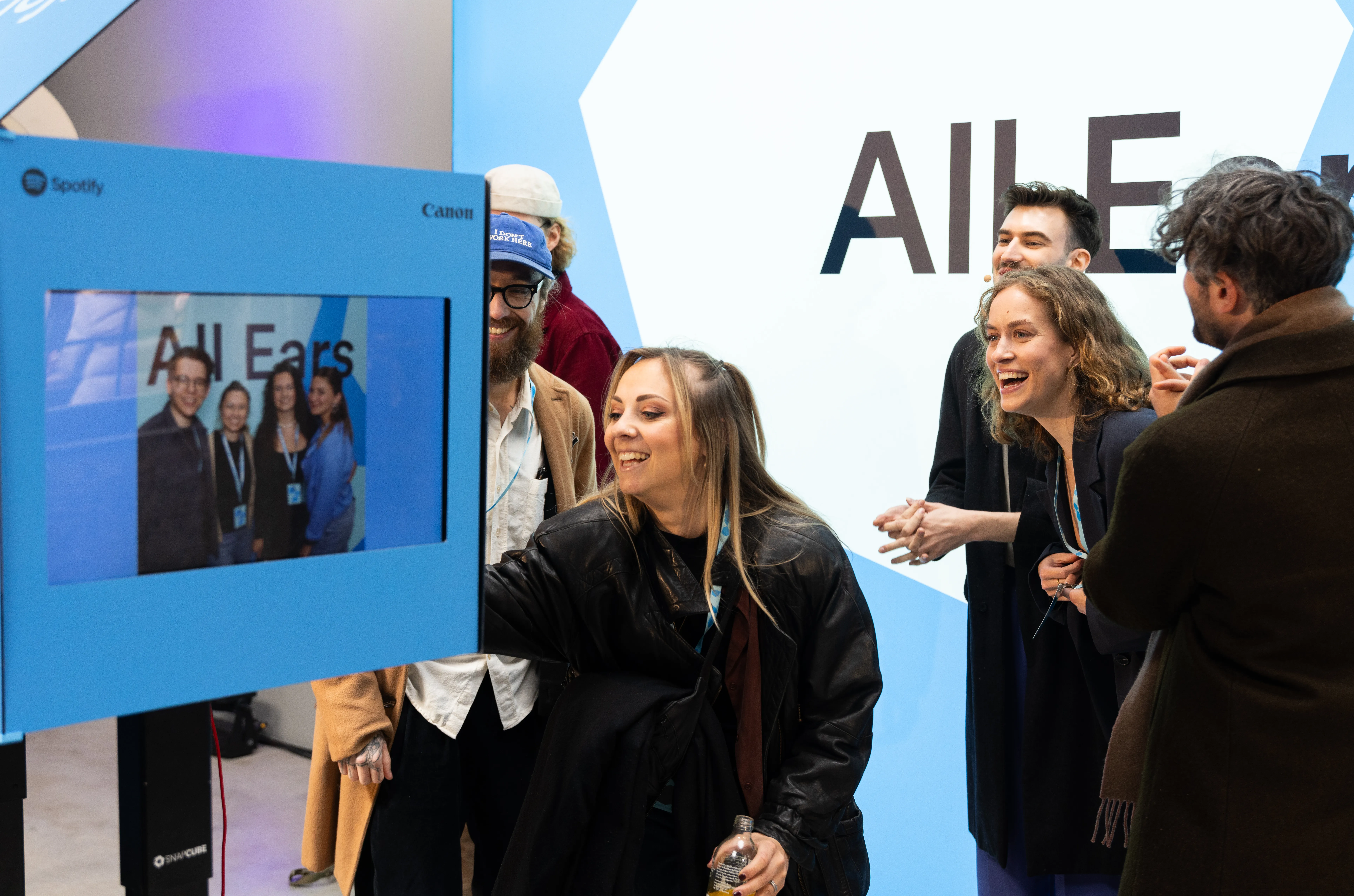 Besuchergruppe nutzt eine SnapCube Fotobox und betrachtet das entstandene Foto