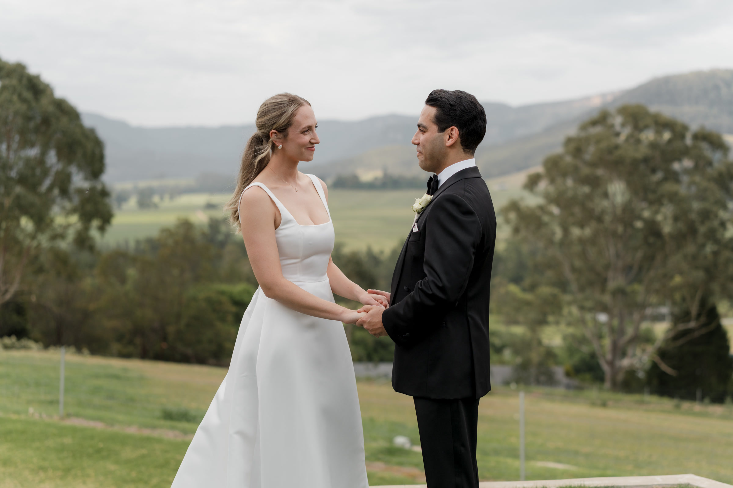 Newly married couple holding hands during a quiet portrait session in the countryside