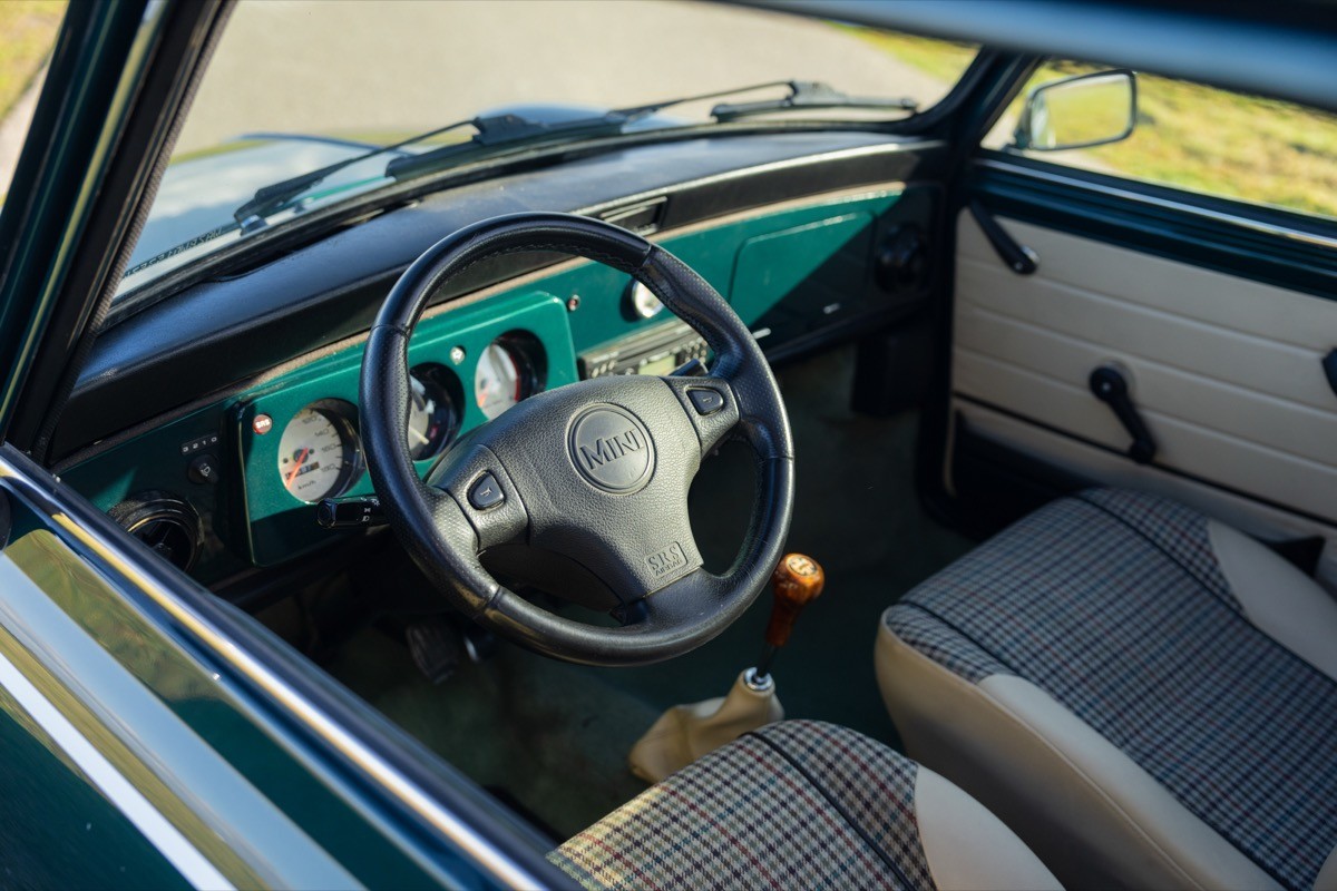 Interior of a vintage car, featuring a steering wheel, dashboard, and seats in a classic style.