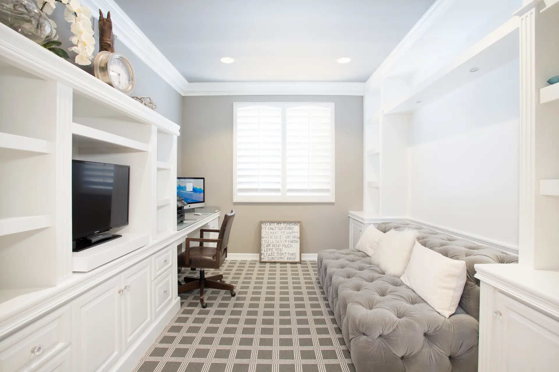 Bright home office with white cabinetry, plush seating, and patterned rug in Newport Beach Remodel.