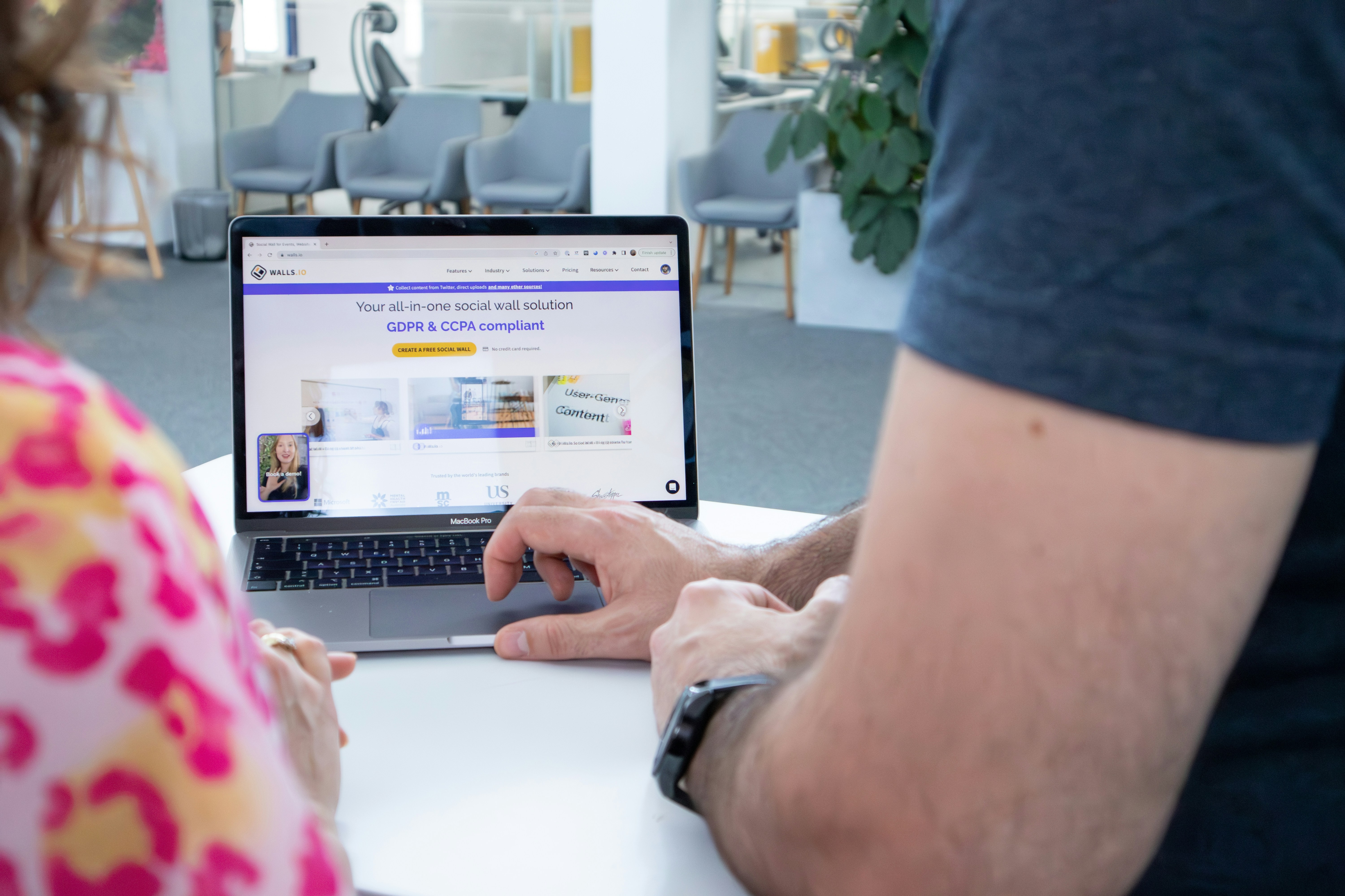 a man and a woman sitting at a table with a laptop