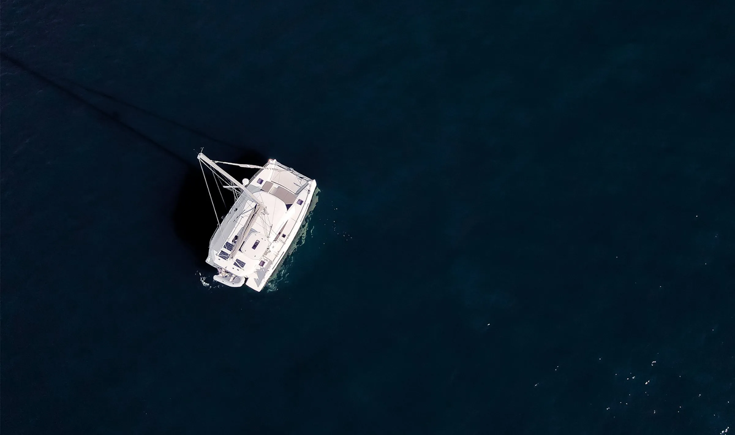 Aerial view of the hosts’ white catamaran Everything Zen on dark blue water off Charleston