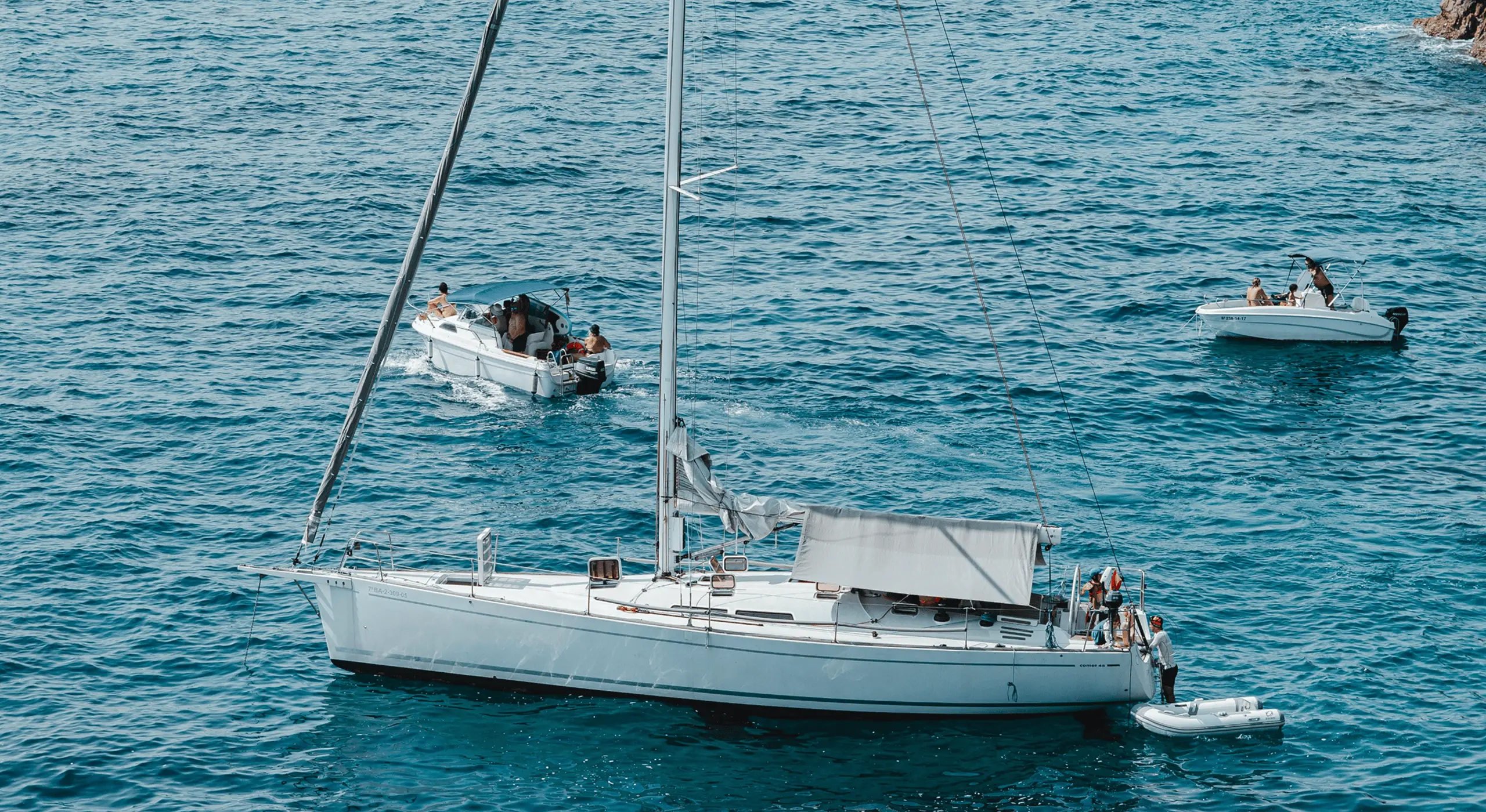 Several white yachts and sailboats on the ocean.
