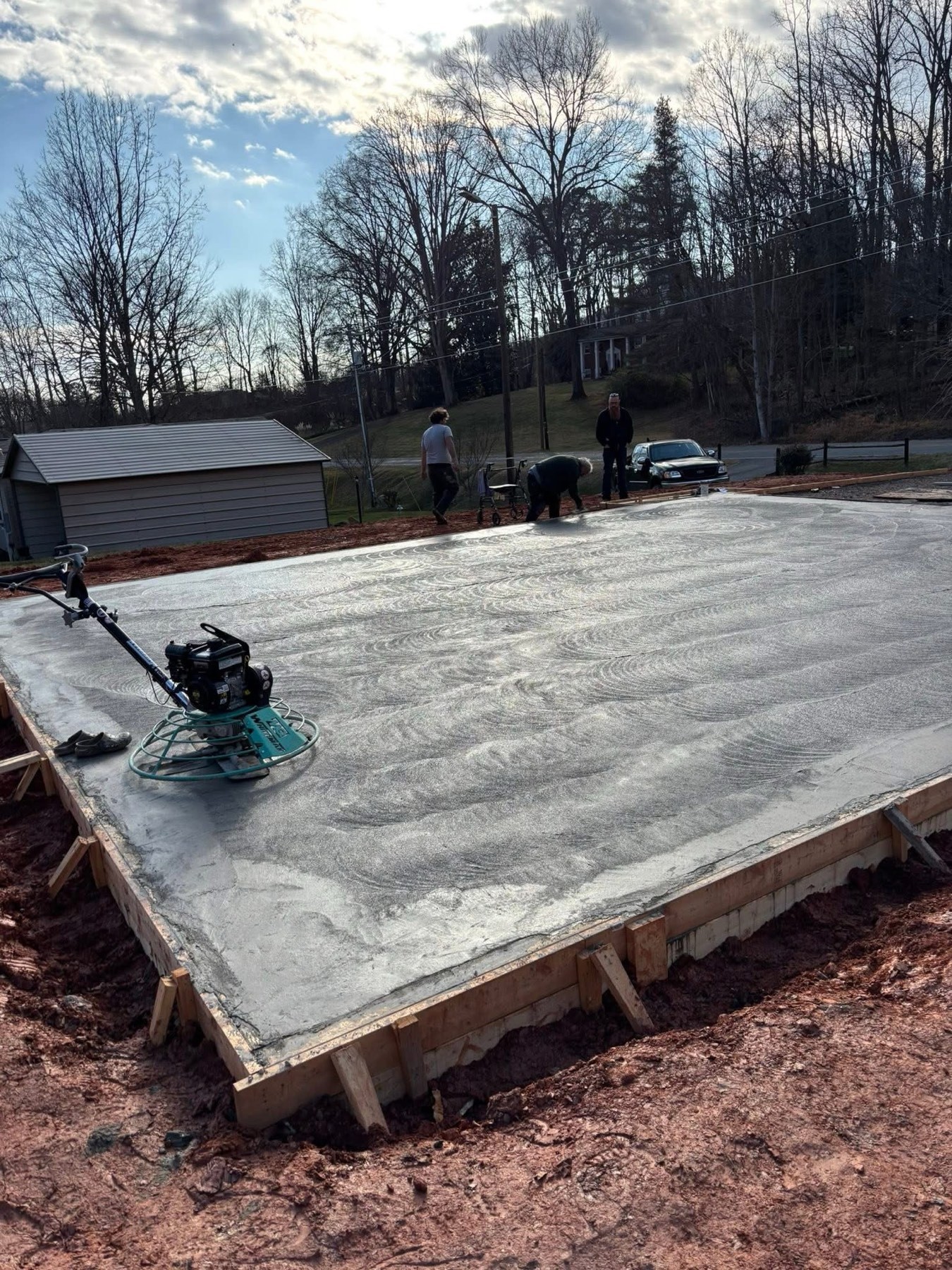 Crew power troweling a large concrete slab