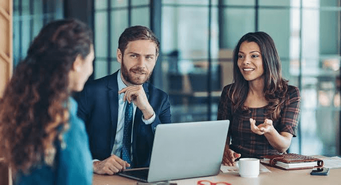 Diverse professional team collaborating around a laptop
