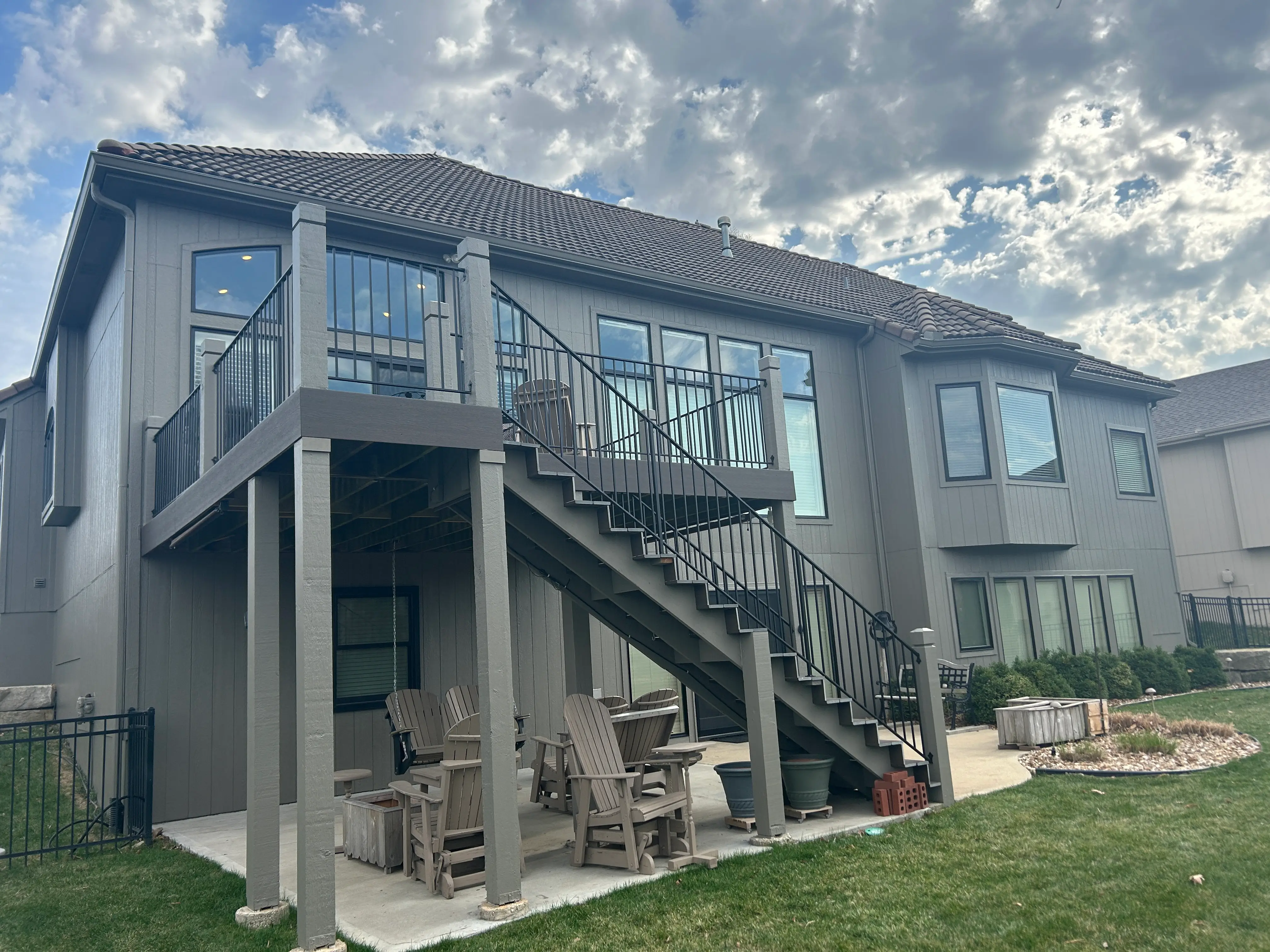 An image of stairs leading up to a second story grey deck.