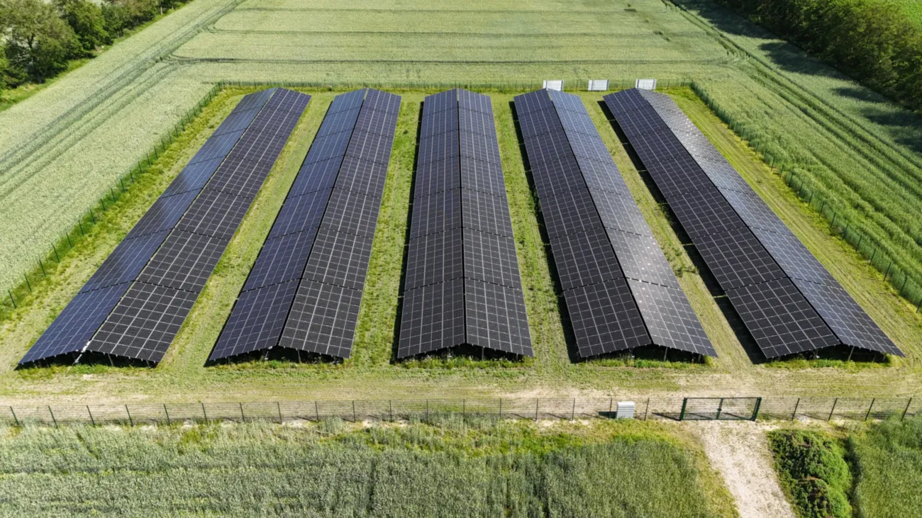 Luftaufnahme eines Bauernhofs mit Biogasanlage, Solaranlagen und Feldern.