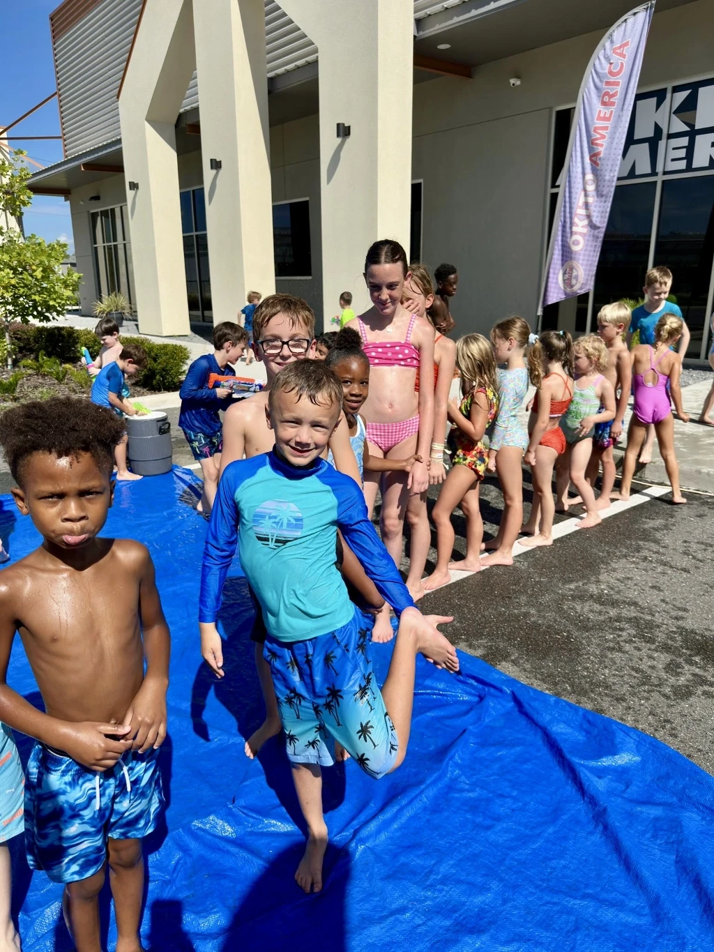 Kids standing in line to go on a water slide.