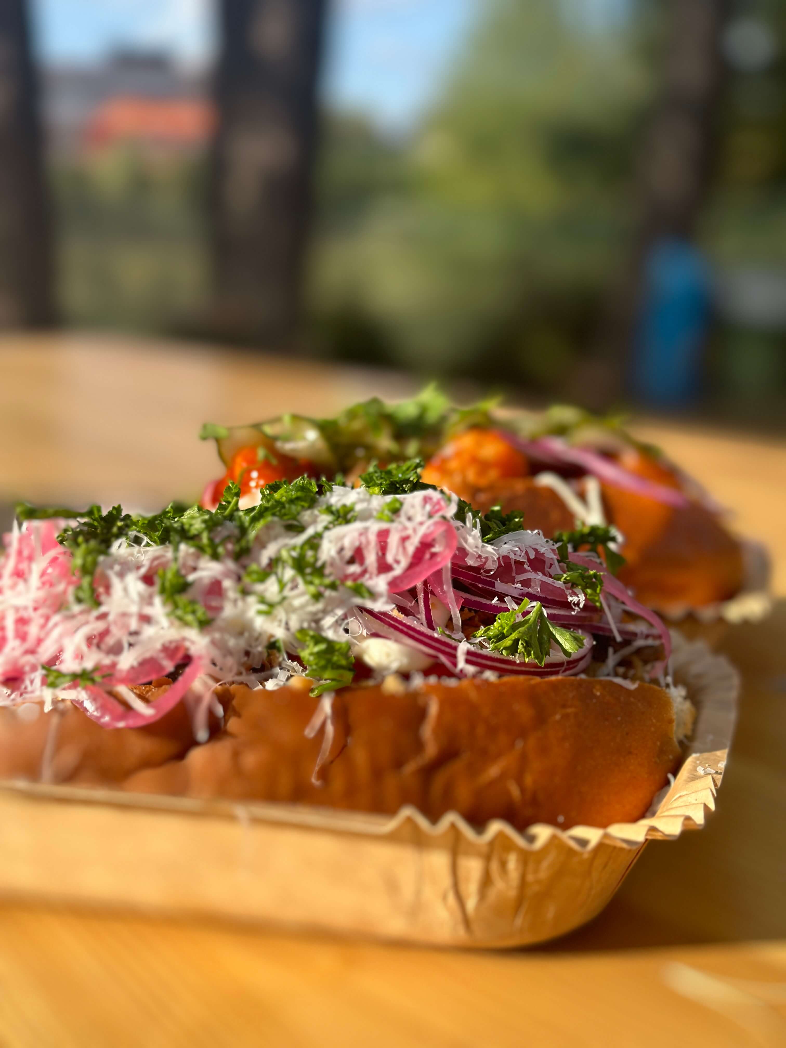 Närbild på Oss bröd emellan's Steak Cheese med picklad lök och färska örter