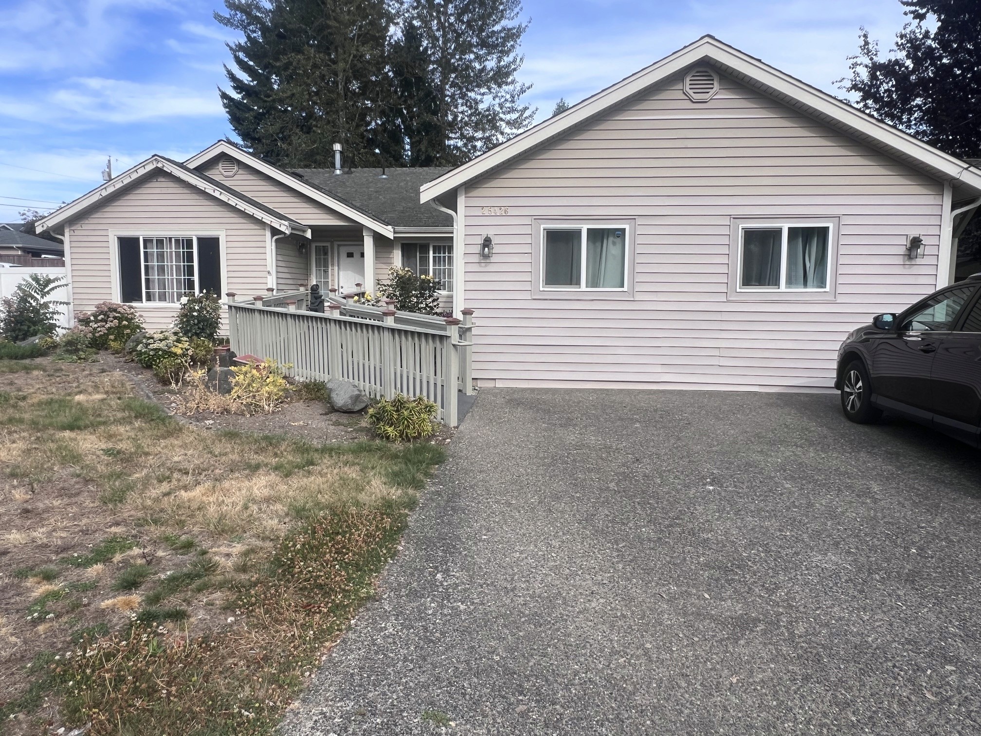 The Abba Care house from the street: a single-storey home with a railed front porch and garden beds