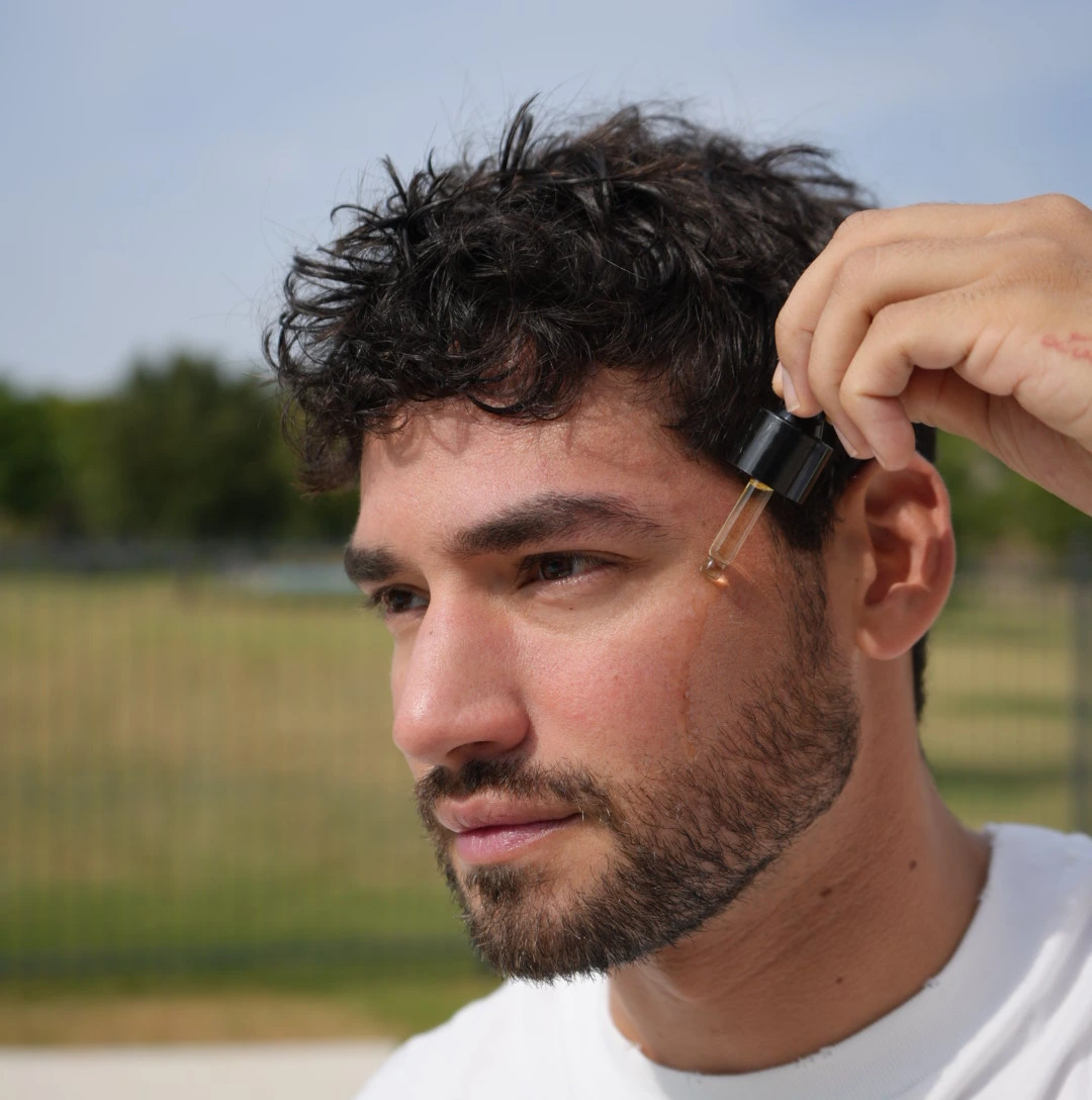 Man using lightweight facial serum to smooth texture, enhance glow, and improve overall skin clarity.