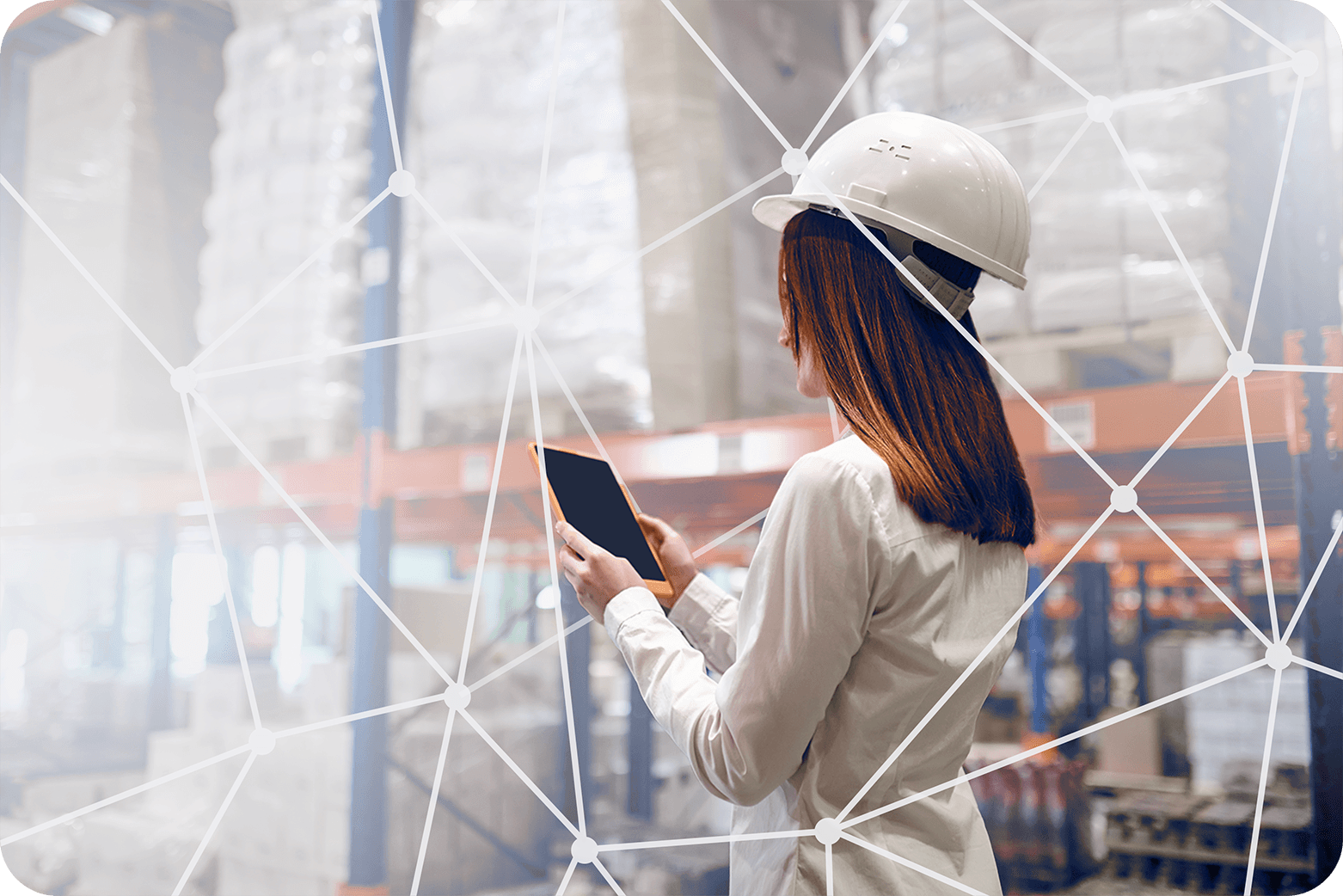 mulher em um centro de distribuição com capacete de engenharia enquanto mexe em um tablet, cercada por linhas de conexões tech