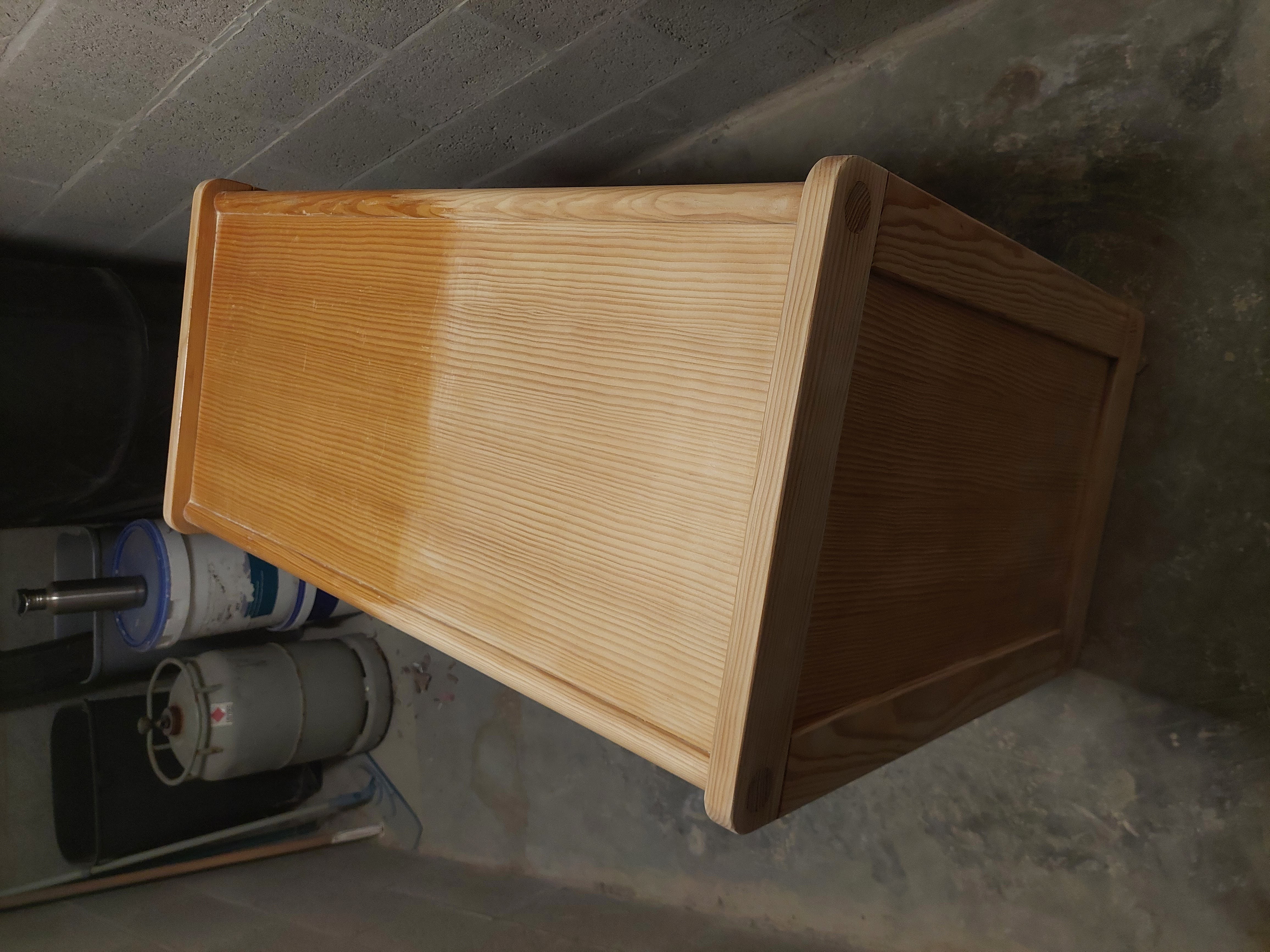 Een houten commode die voor de helft geschuurd is