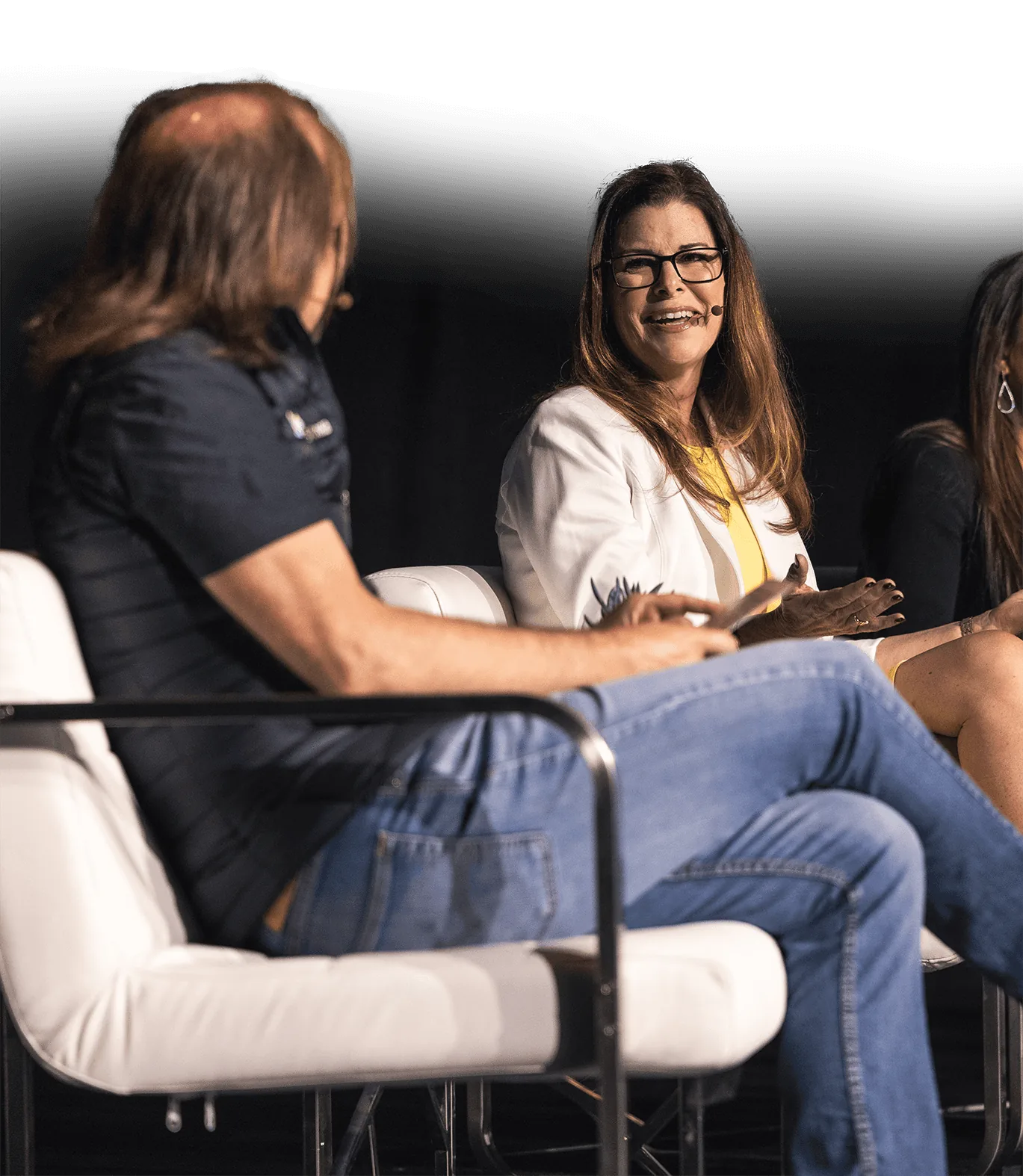 Laughing panelist in a white blazer and glasses on a SynBioBeta panel
