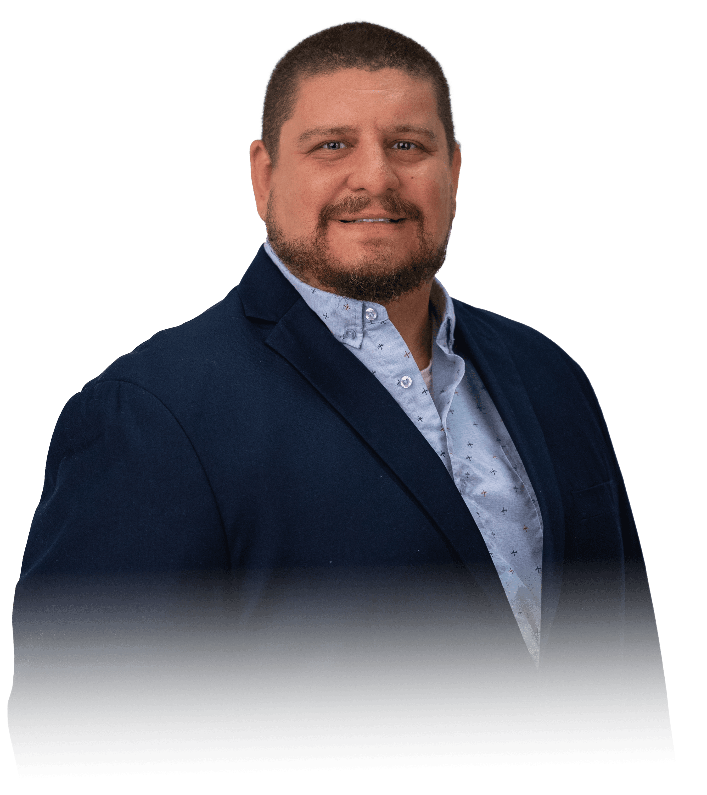 Two people in a workshop, one standing and smiling while the other leans over a car, working on it.