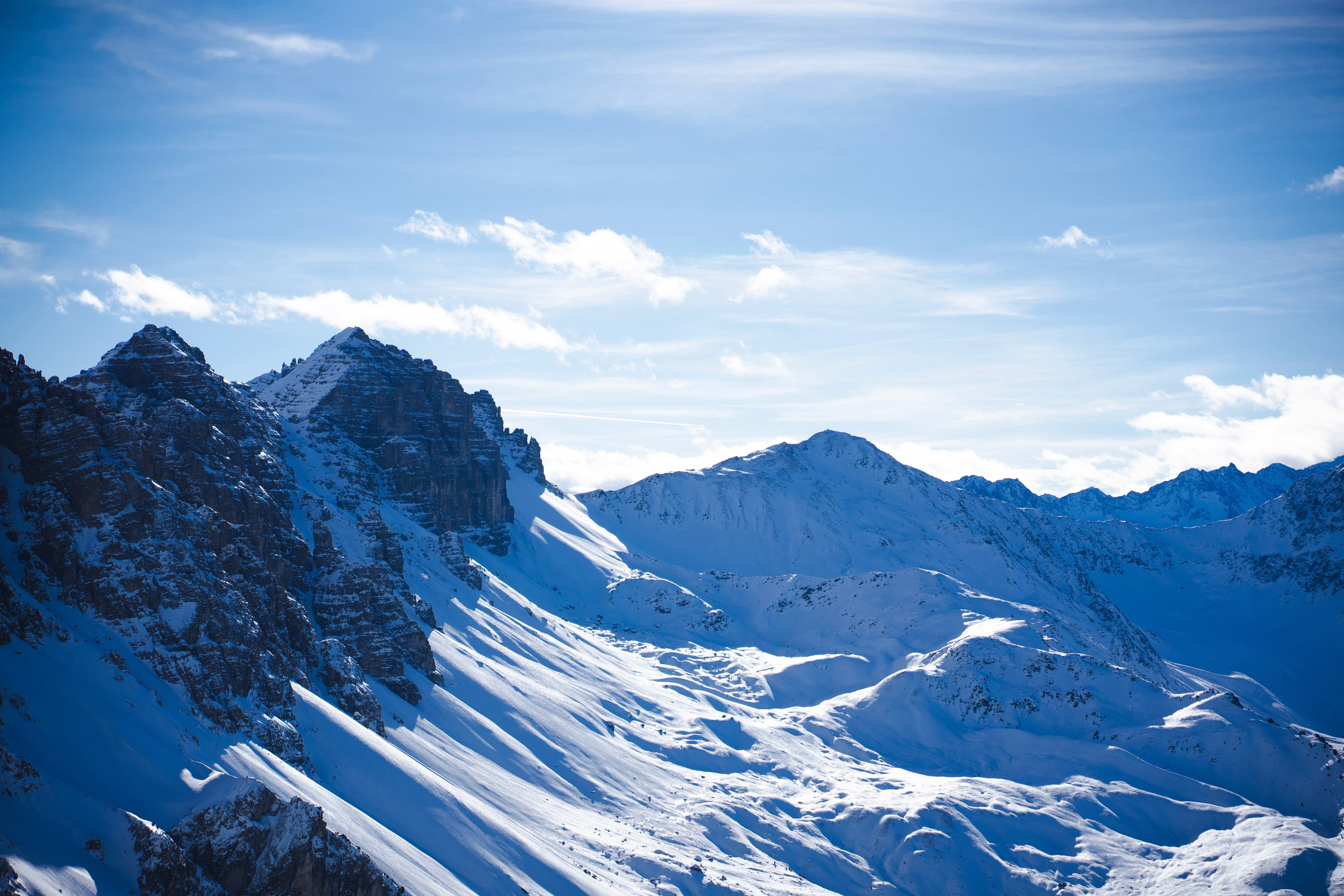 Snow-covered mountain peaks under clear blue sky.