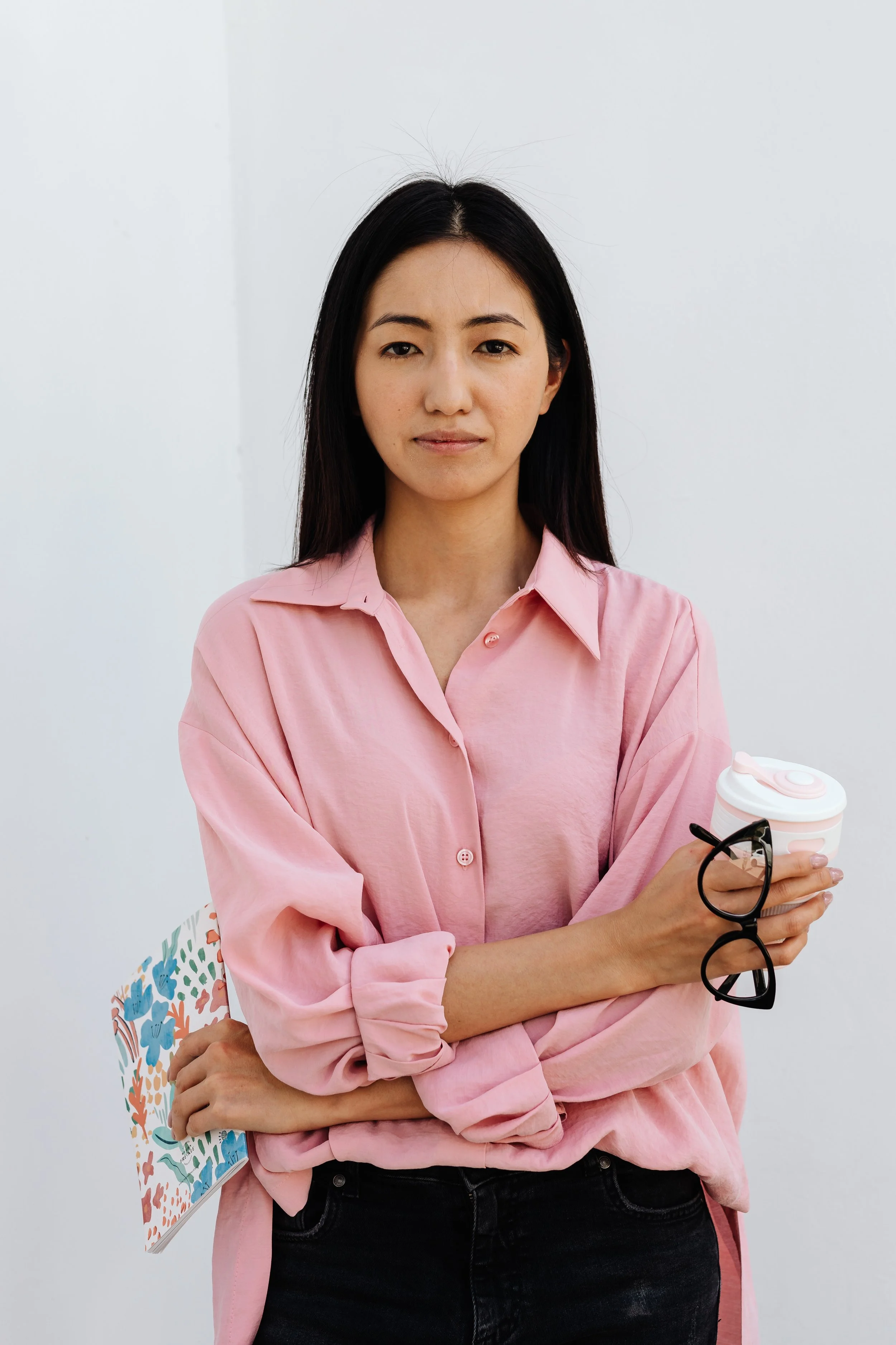 An Asian woman holding many things, both literally and figuratively
