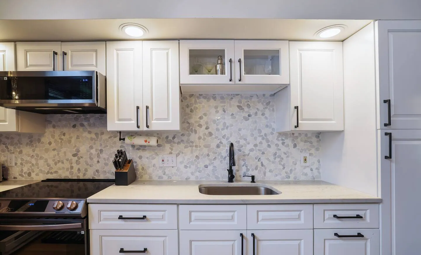 Kitchen with white cabinets, mosaic backsplash and stainless appliances at Get Lucky On Lupine