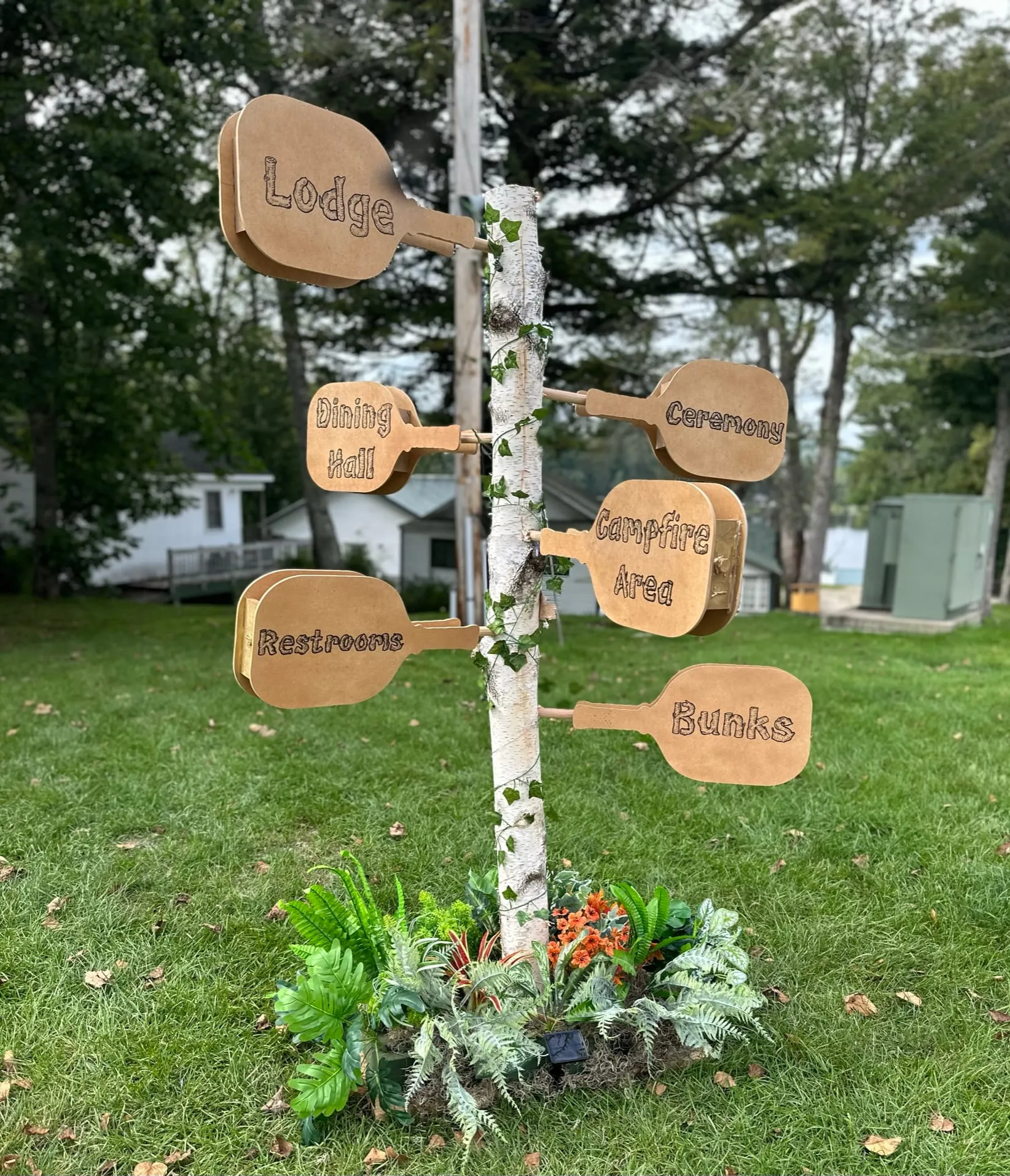 Wooden directional signs for lodge, dining hall, and bunks at Camp Lenox