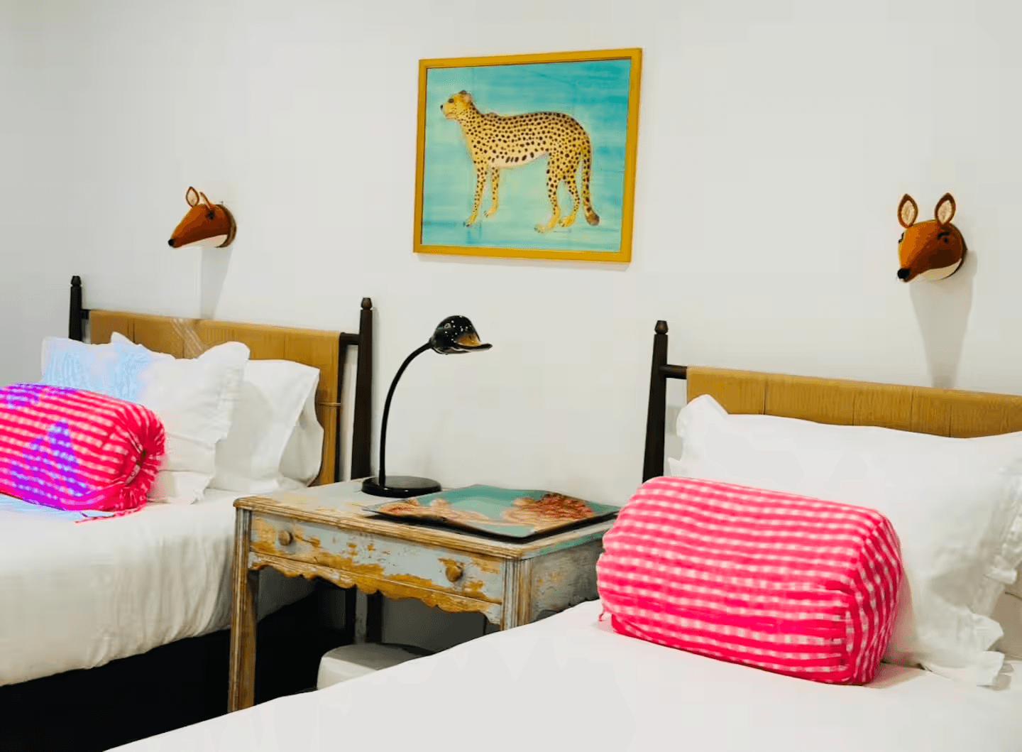 Twin bedroom in Soul & Sea condo 4 with playful animal artwork and pink accents