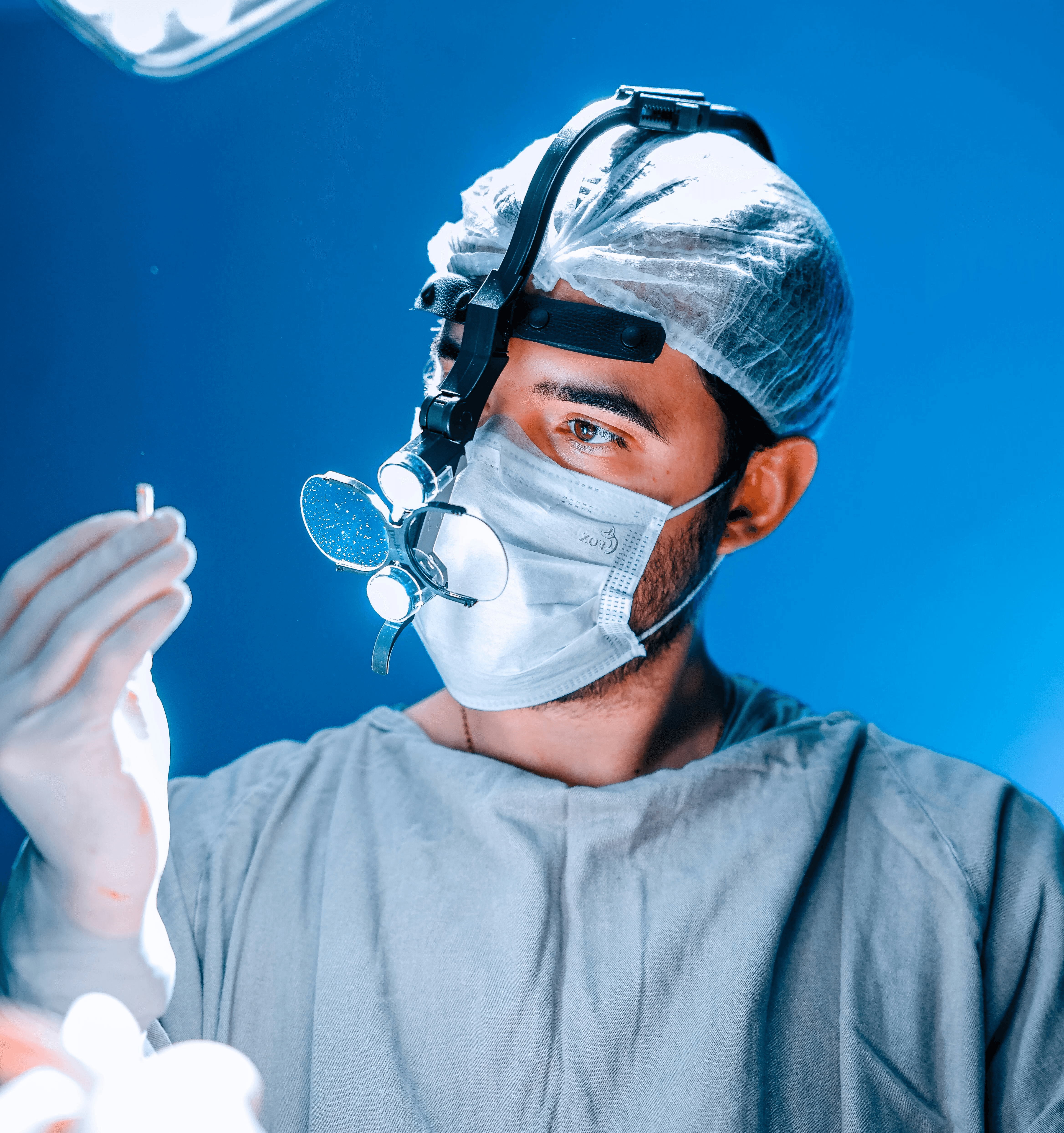 A surgeon examines a medical instrument during surgery.