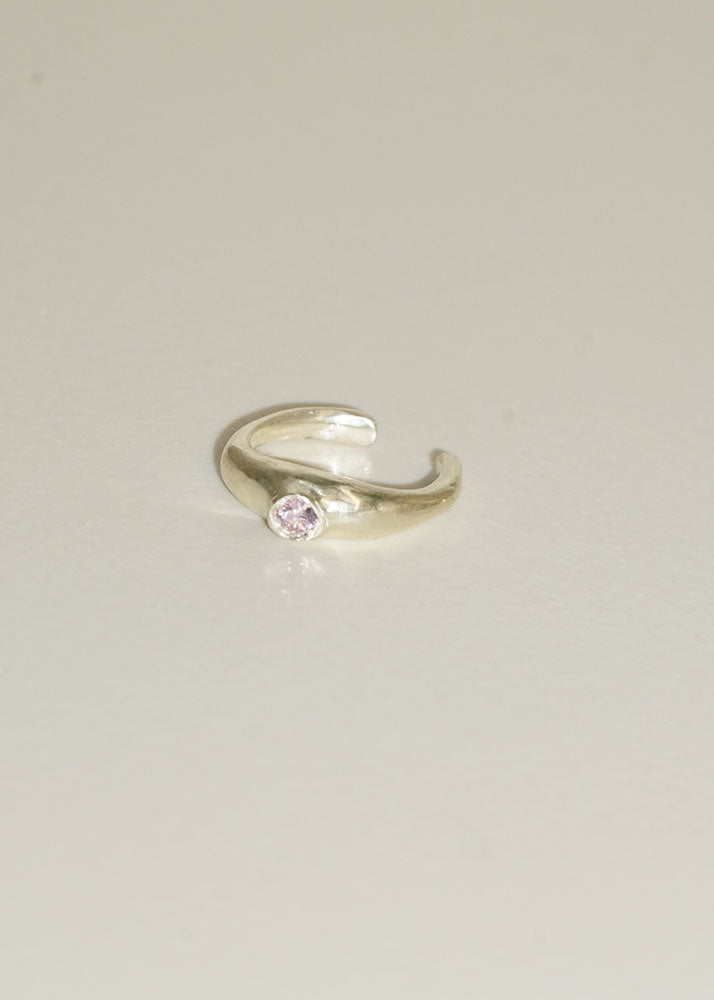 Silver ring with a pink gemstone on a light gray background