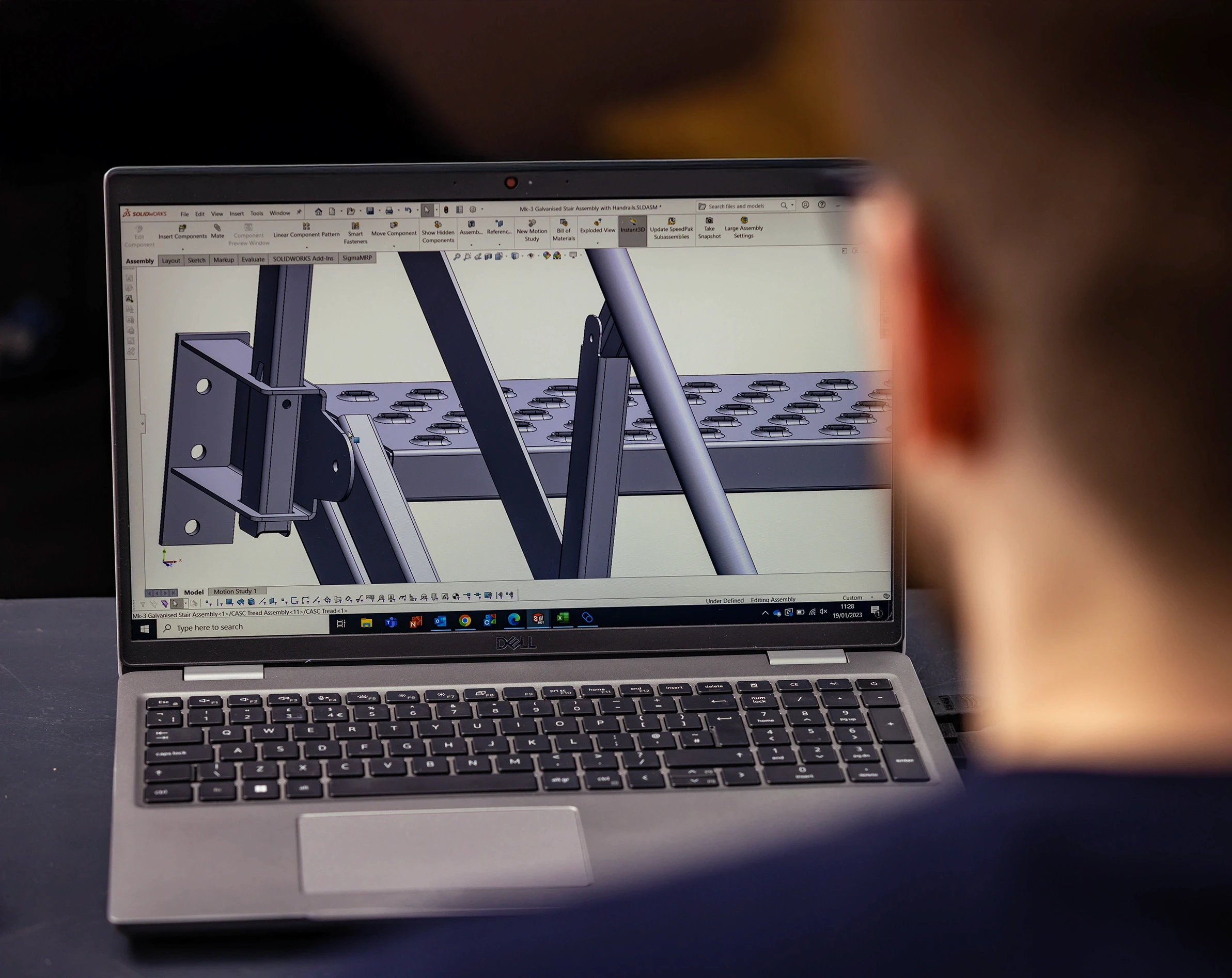 A CASC engineer designing a custom steel assembly using SolidWorks CAD software on a laptop.