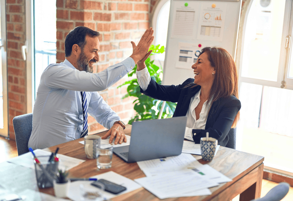 Female and male professionals exchanging a high-five