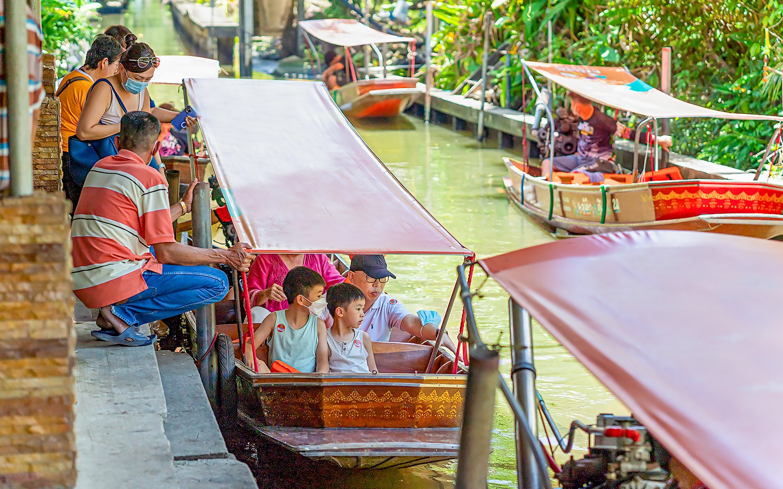 Besøgende på en bådtur ved Damnoen Saduak Floating Market, Thailand.