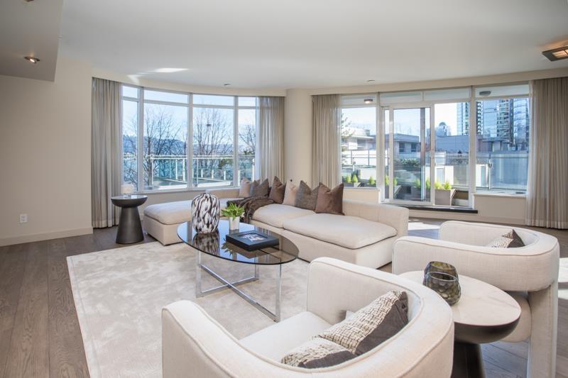 Bright modern living room with white furniture and large windows showcasing a city view.