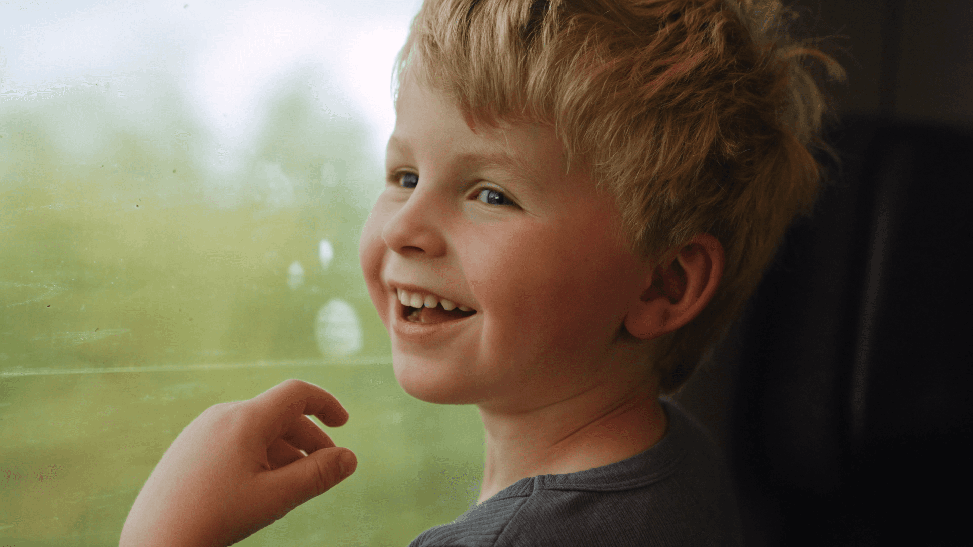 A kid looking out a window.