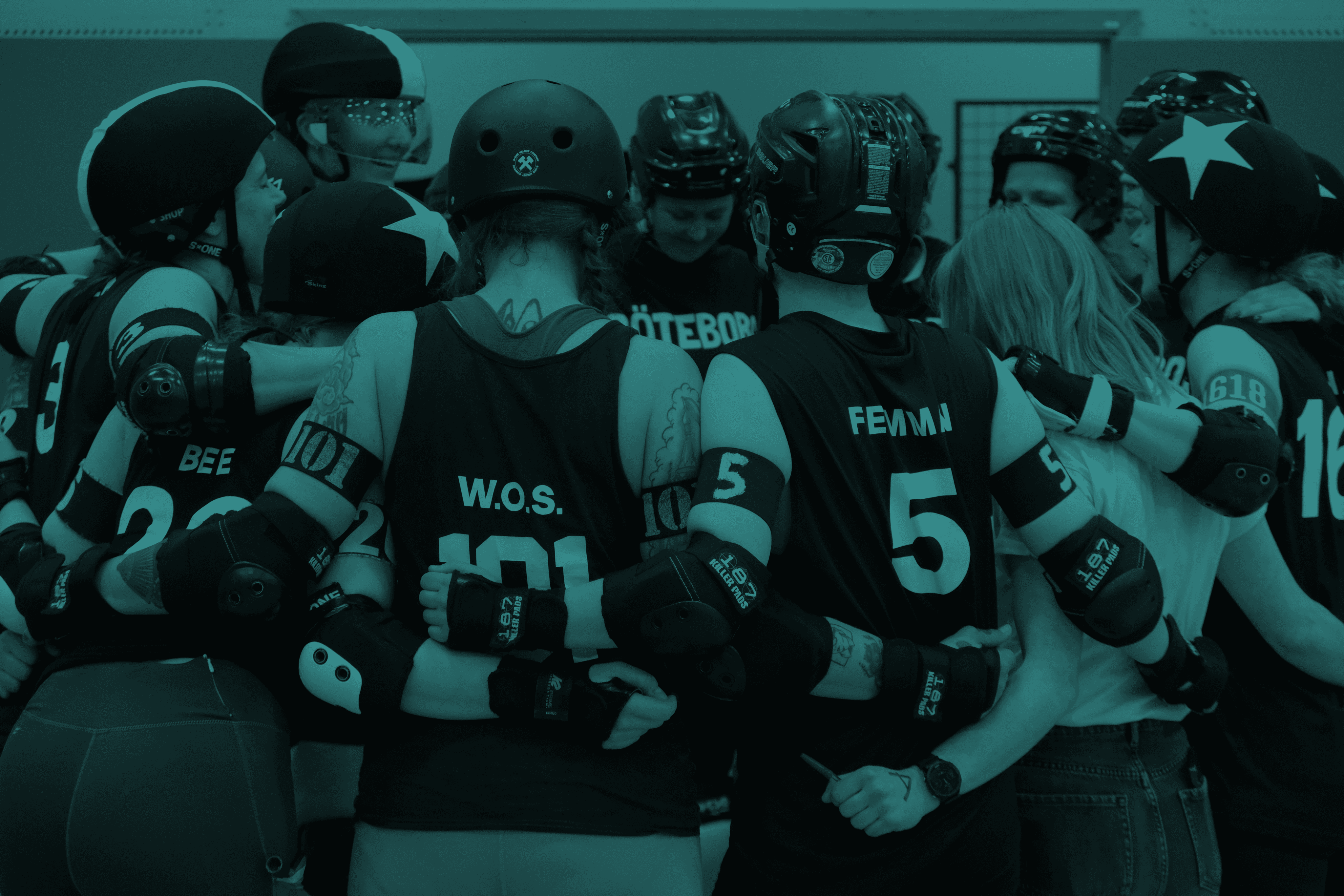 A roller derby team standing in a circle holding each others backs.