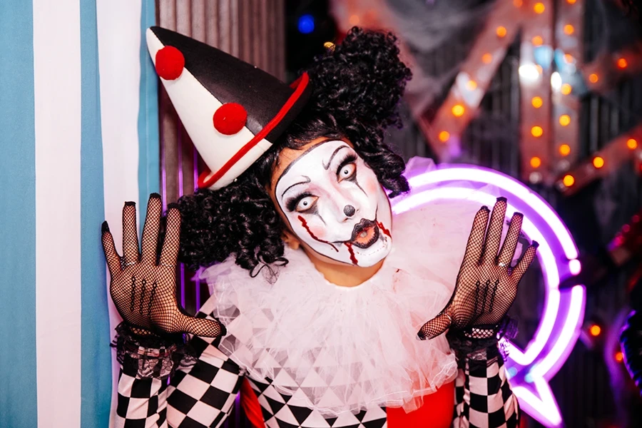 Pierrot clown performer in black-and-white checks and a pointed hat
