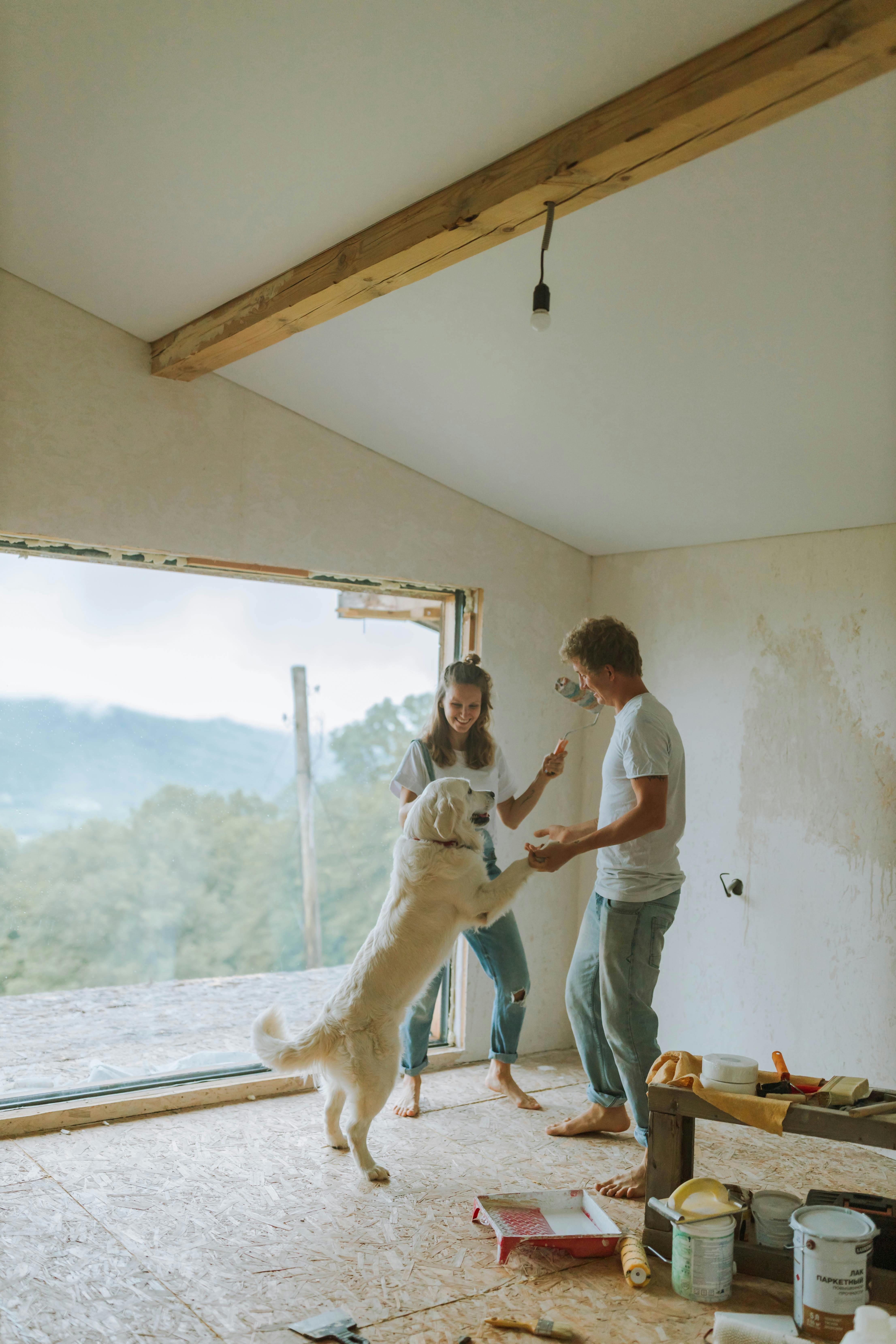 A couple in an unfinished room surrounded by renovation tools, capturing life mid-renovation | homeowner hq
