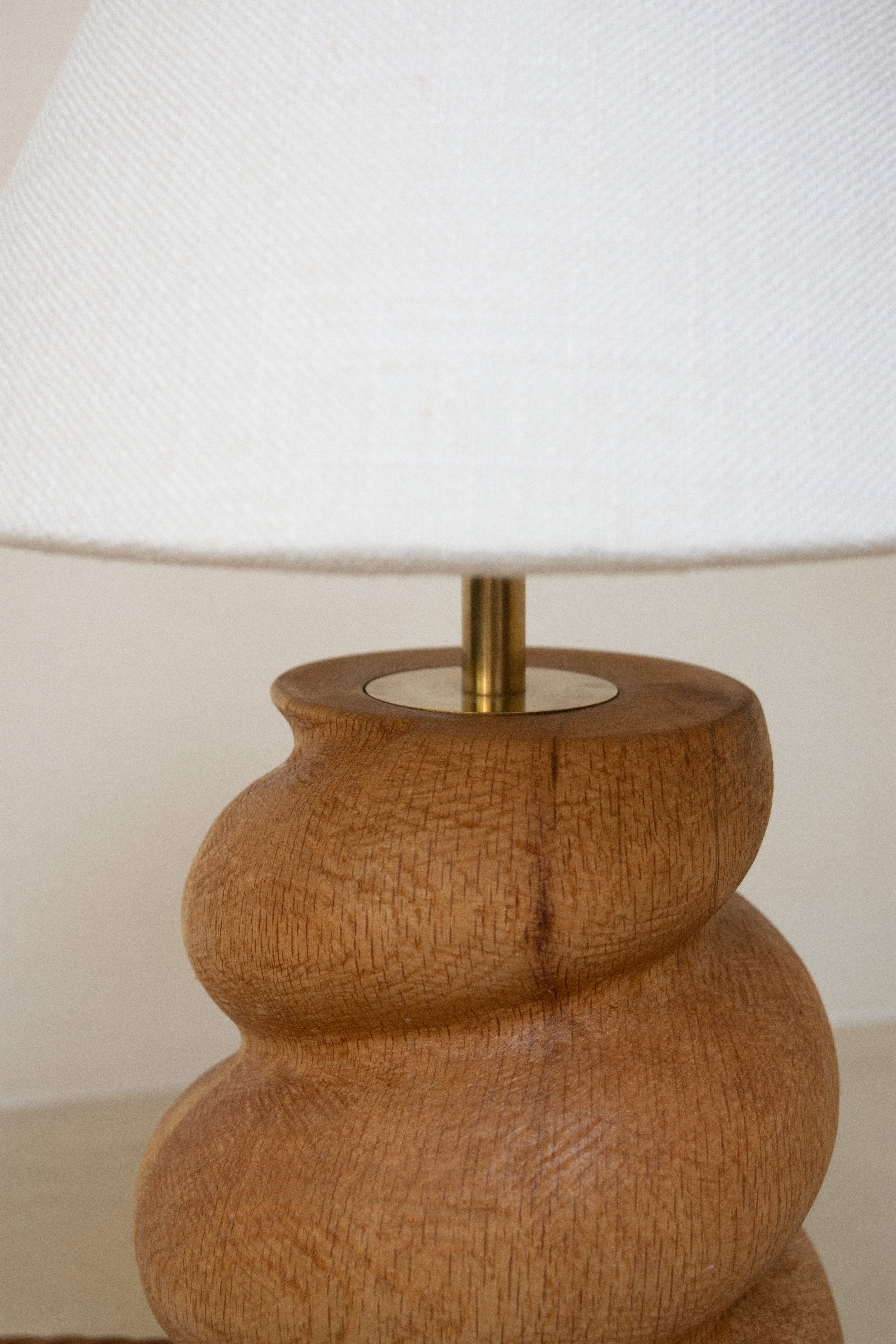 Close up of Caracol Table Lamp in Oak showing wood carving and brass detail
