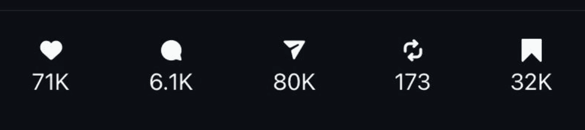 Una persona con una camiseta negra y pantalones de color claro está de pie en la cima rocosa de una montaña al atardecer, sosteniendo una cámara frente a su cara para tomar una foto. Un mar de nubes se extiende detrás de ellos, iluminado por la luz dorada del sol poniente.