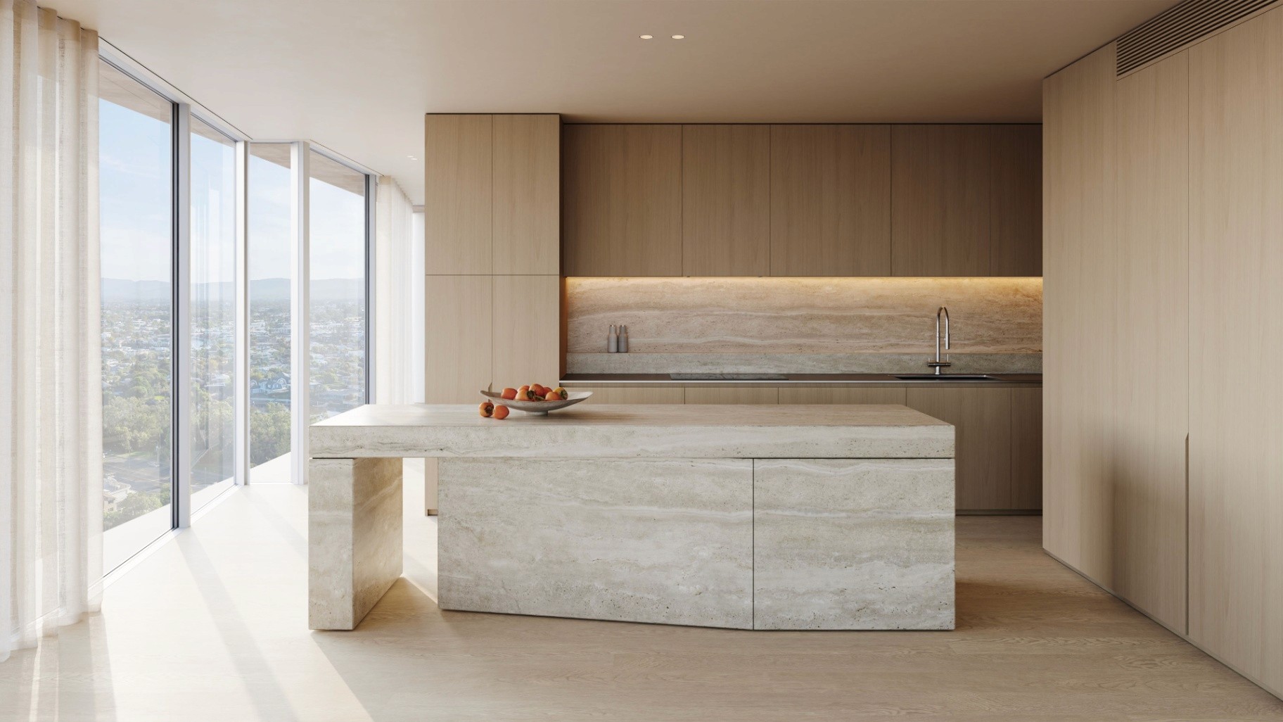 Camilla Broadbeach apartment kitchen featuring travertine stone island, timber joinery, and minimalist coastal finishes.