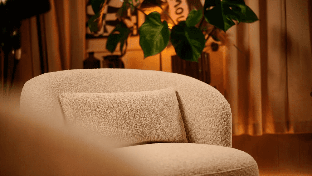 Minimalist entryway with curved walls, pampas grass, and a neutral bench under soft natural light.
