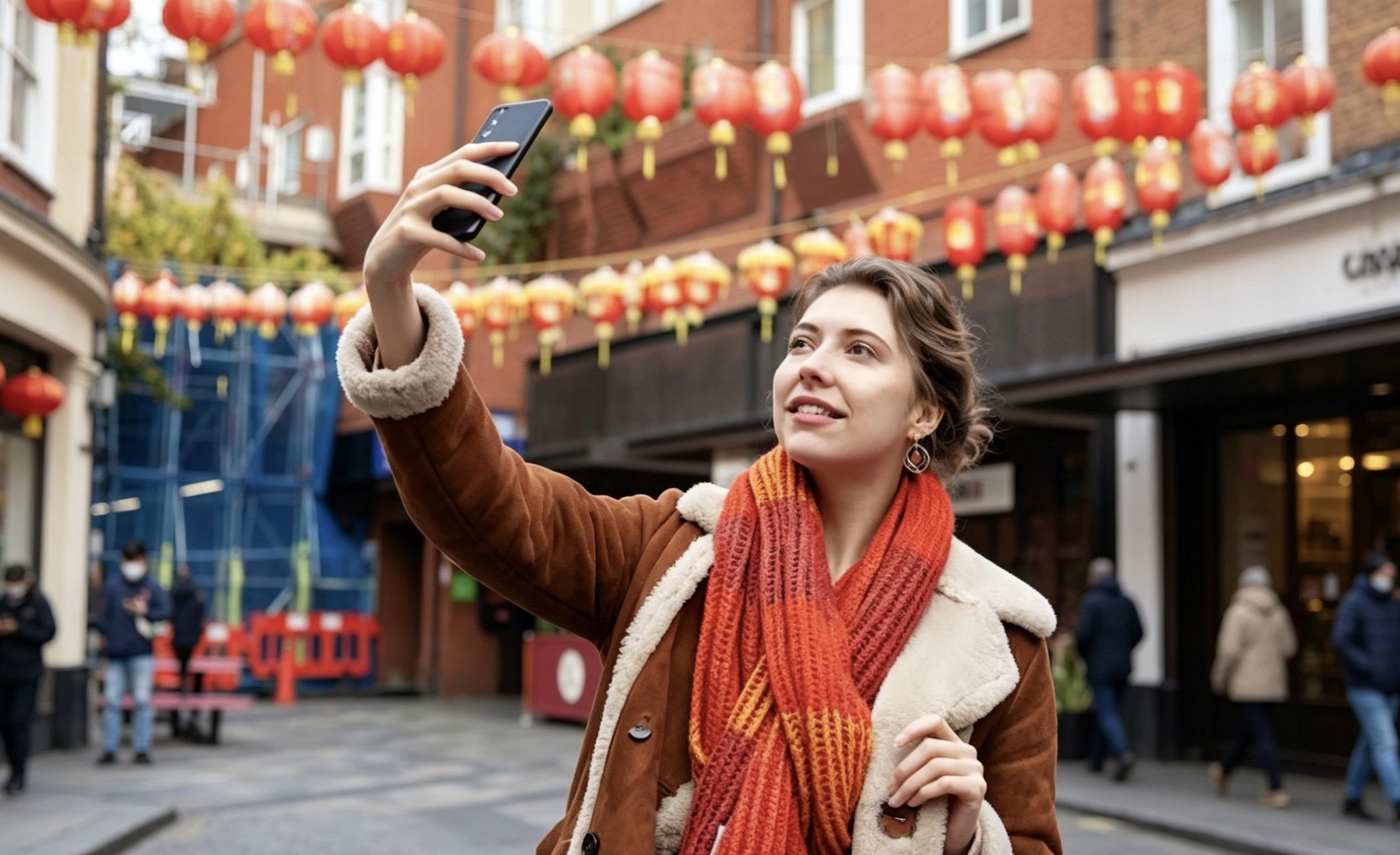 Tourist taking a selfie in a Chinese street decorated with red lanterns