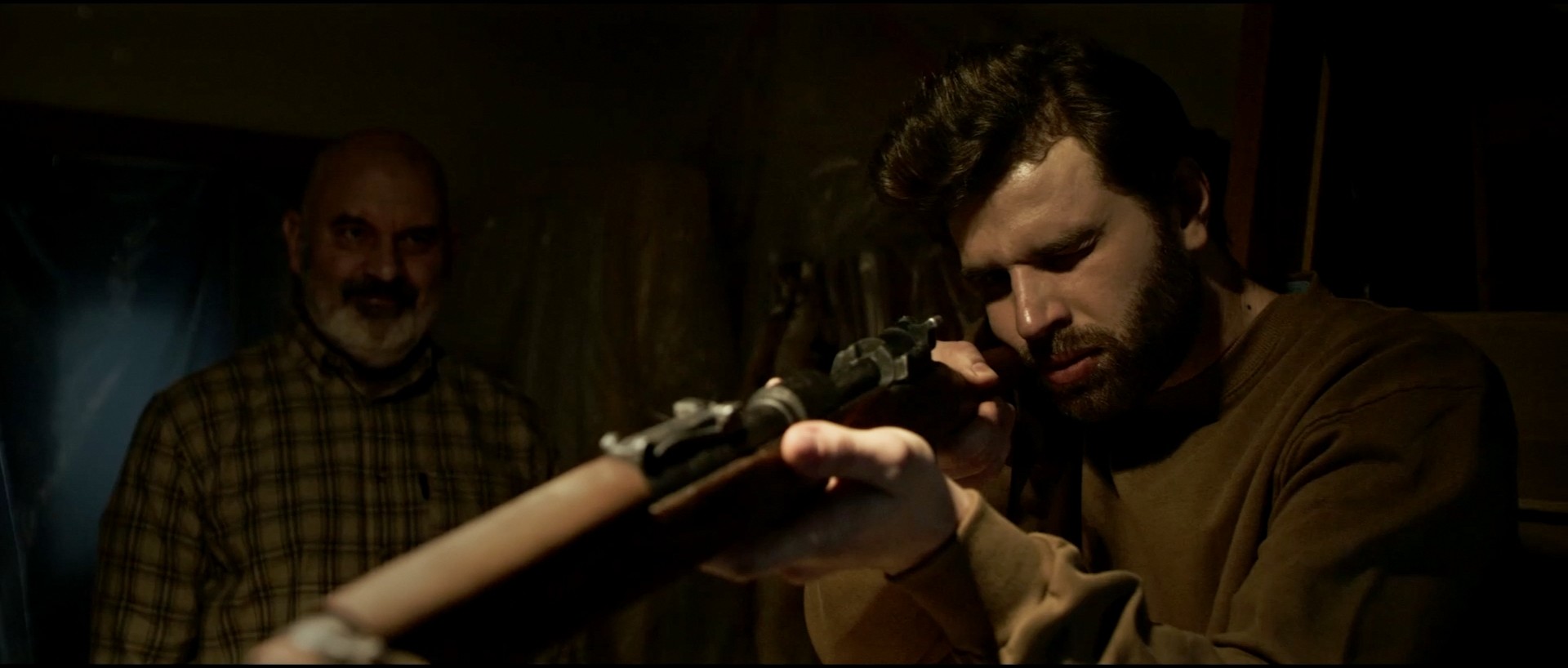 Close-up of hands cleaning a hunting rifle, detailed shot from short film "Tradition".