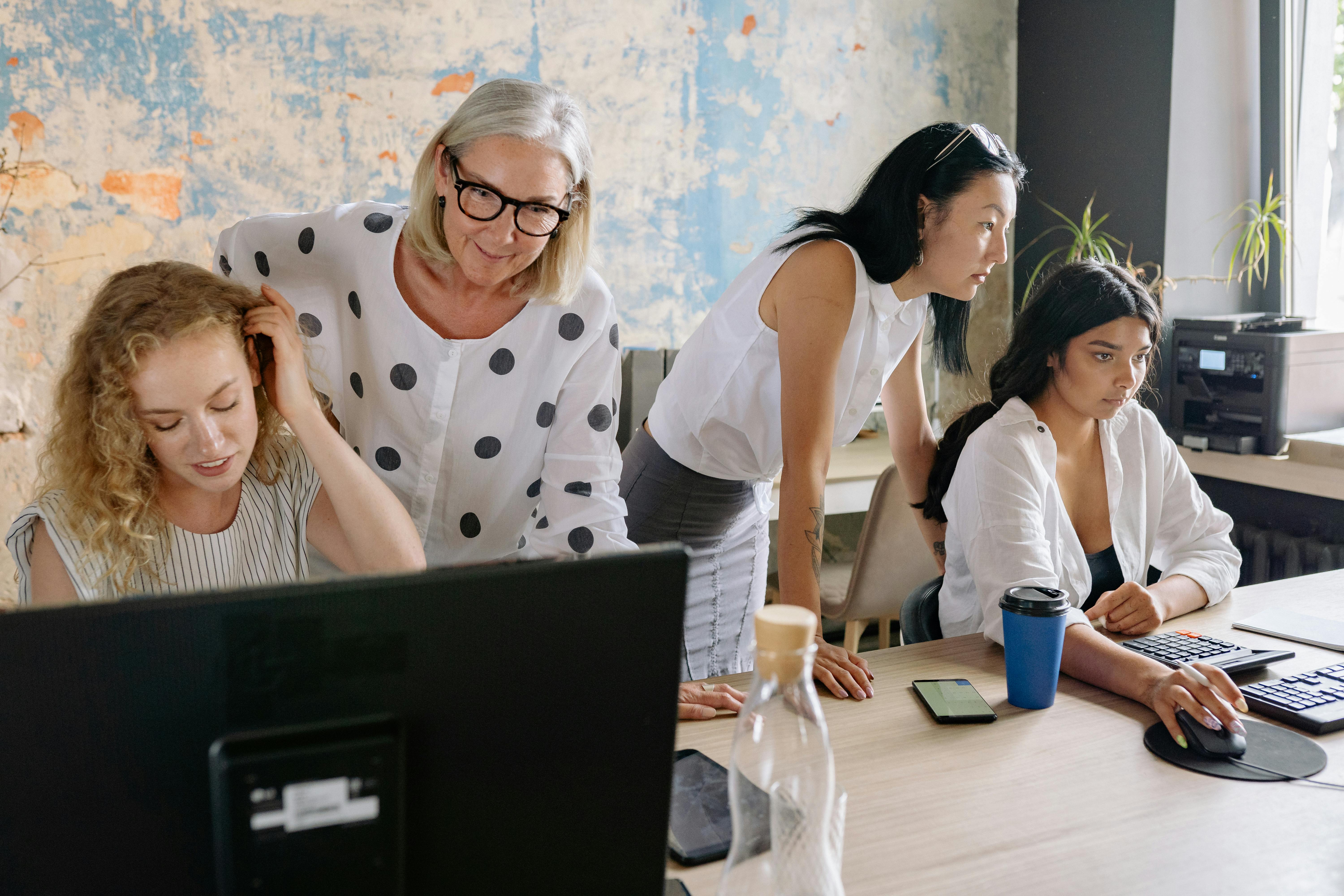 Team femminile collabora in ufficio su progetto digitale e contenuti