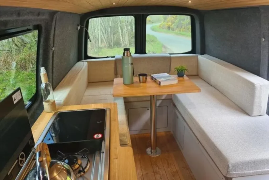 VW Campervan Conversion Layout with futon bed, bench seating and interior kitchen