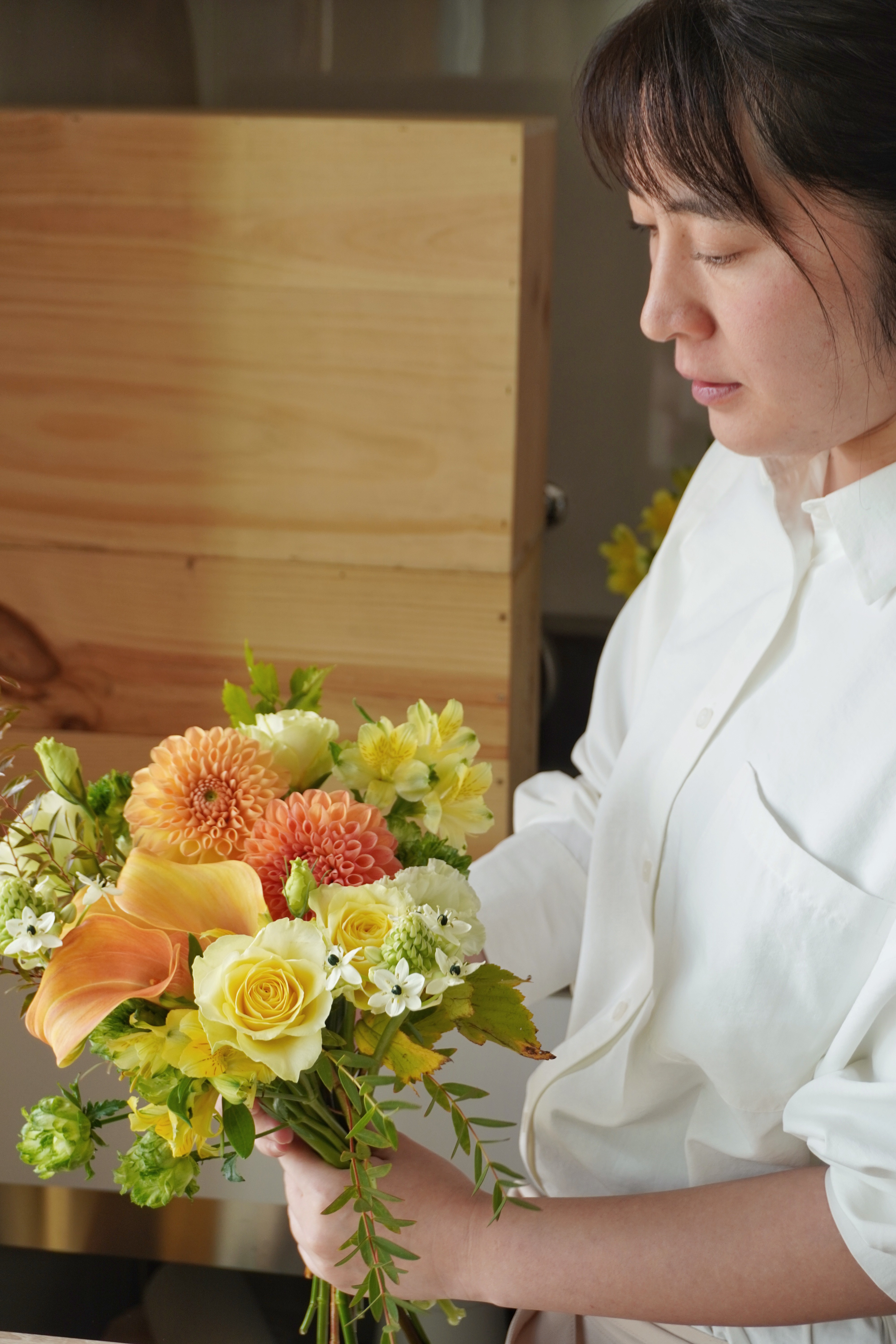 selective focus photo of woman holding sunflower surrounded by sunflowers