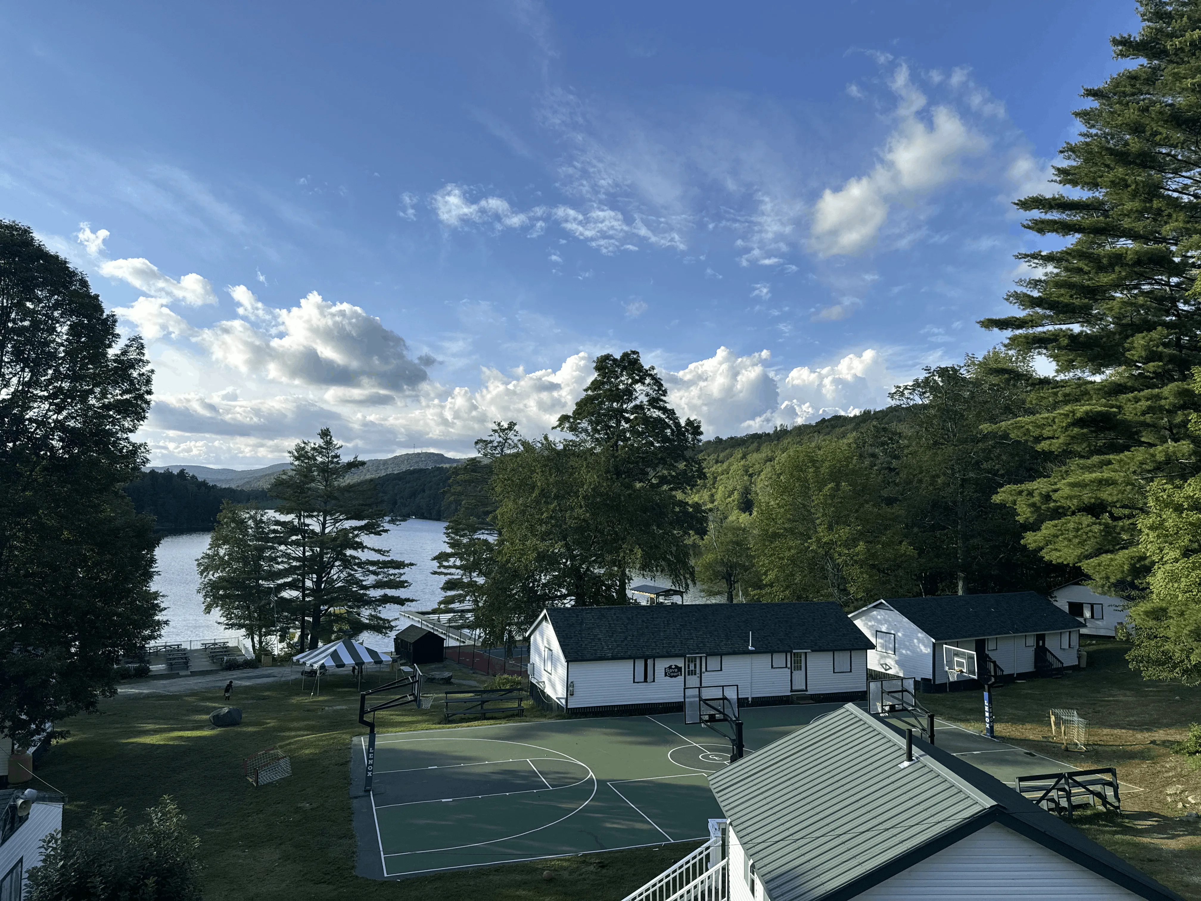 Aerial view of Camp Lenox cabins and lake surrounded by forest