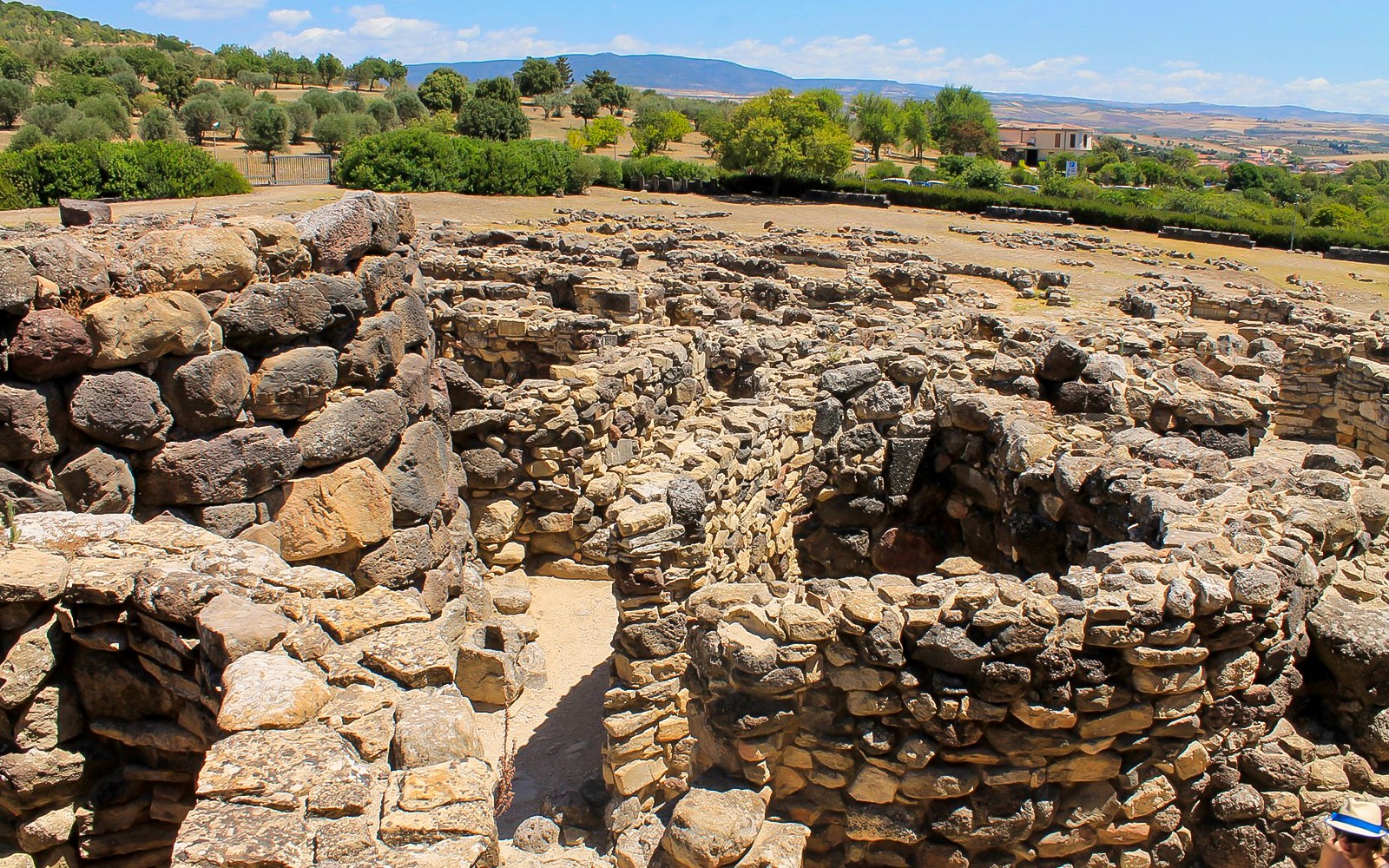 Ancient stone ruins at Barumini UNESCO Site, Sardinia, with surrounding landscape.