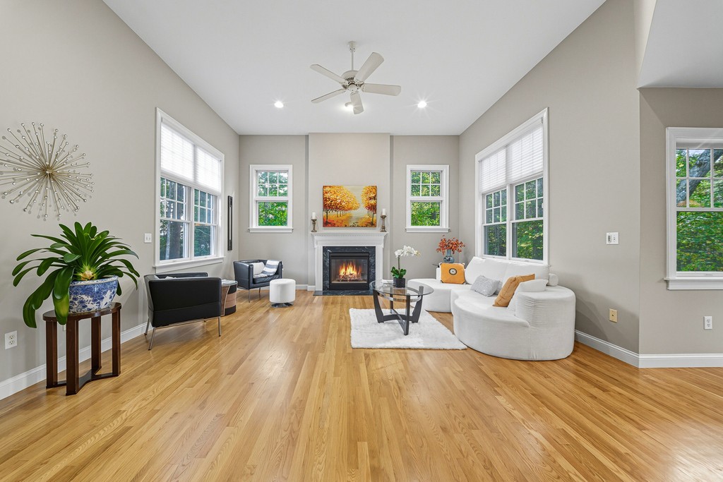 A modern house with large windows and a flat roof, surrounded by greenery against a clear blue sky.