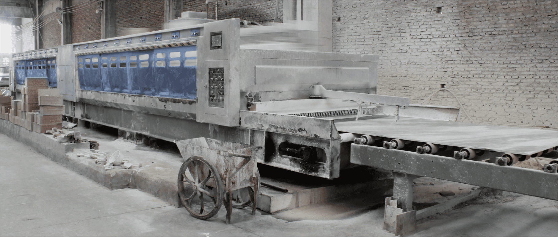 Side view of the Fully-Automatic Polishing Machine in a production setting, showing its robust construction and long conveyor system for processing large stone slabs.