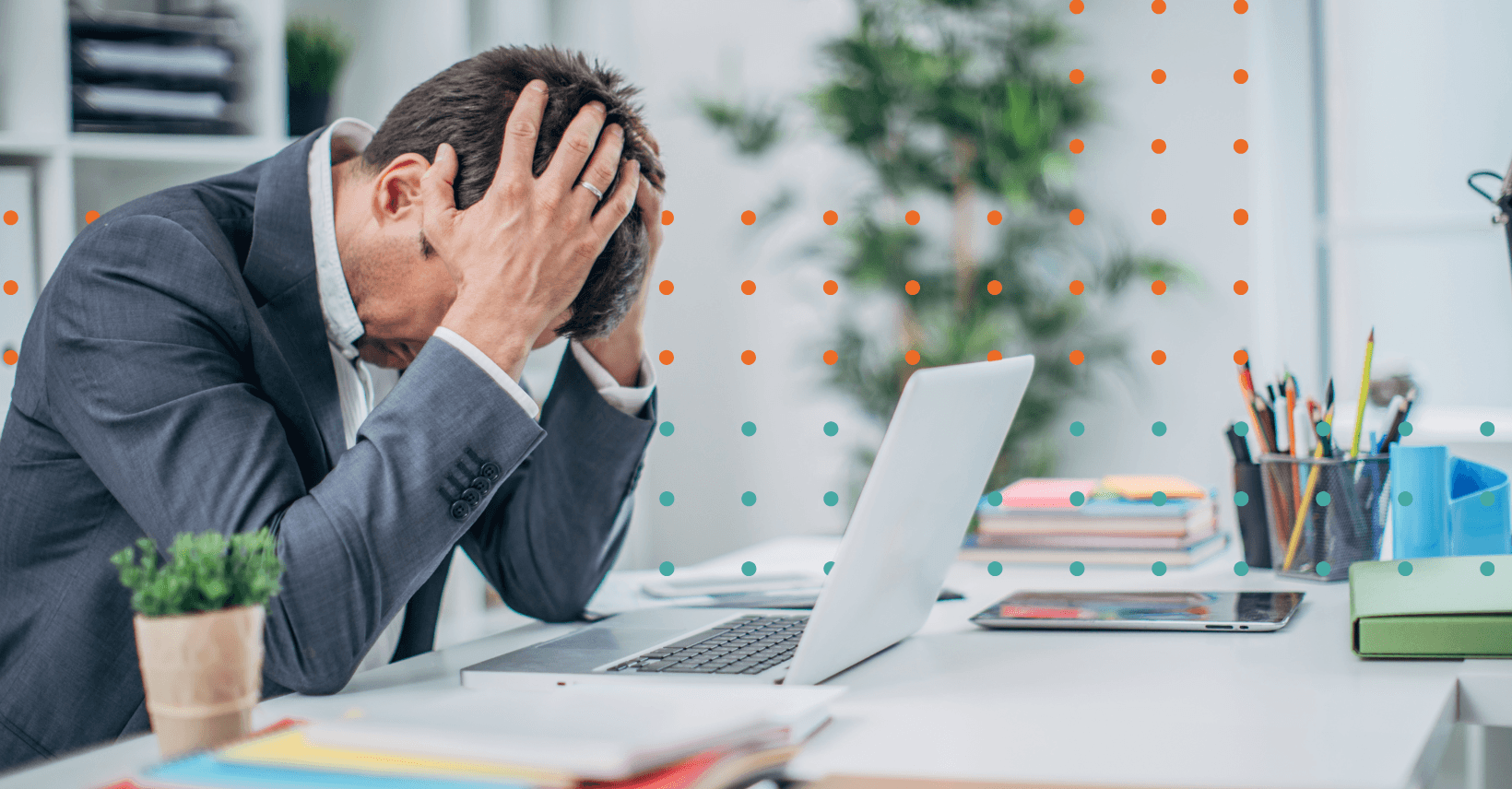 Worker holding head in hands over laptop at desk with dot details in the background