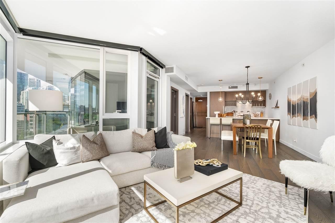 Bright and modern living room with large windows, neutral decor, and a cozy atmosphere. Elegant furnishings throughout.